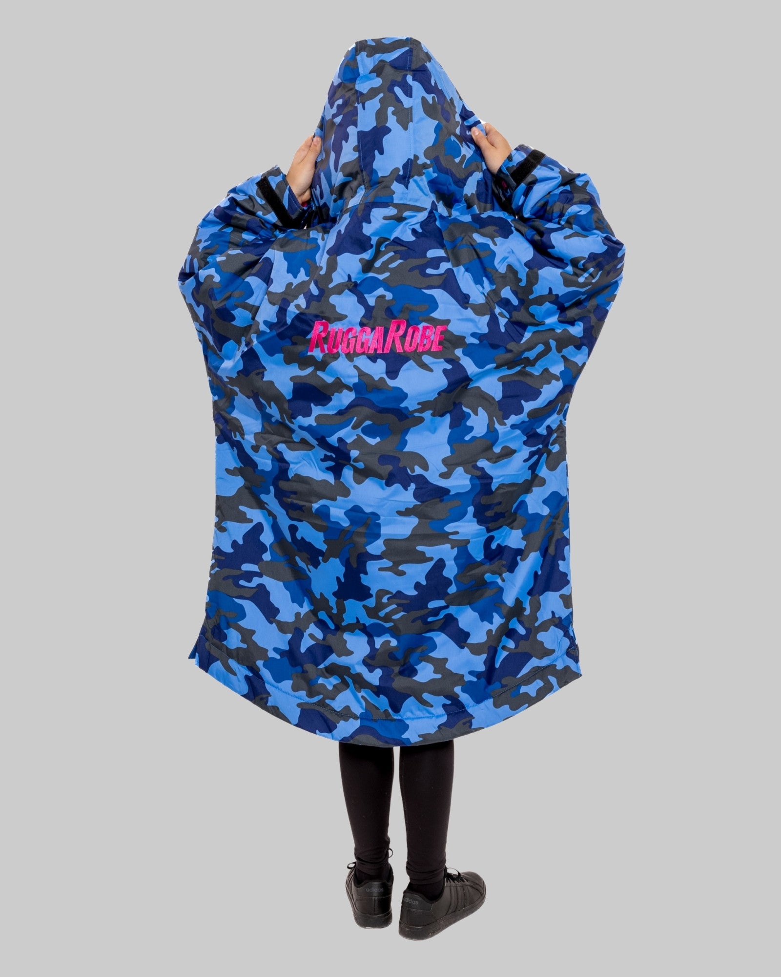 Model wearing RuggaRobe blue camo change robe with pink fleece interior on grey background