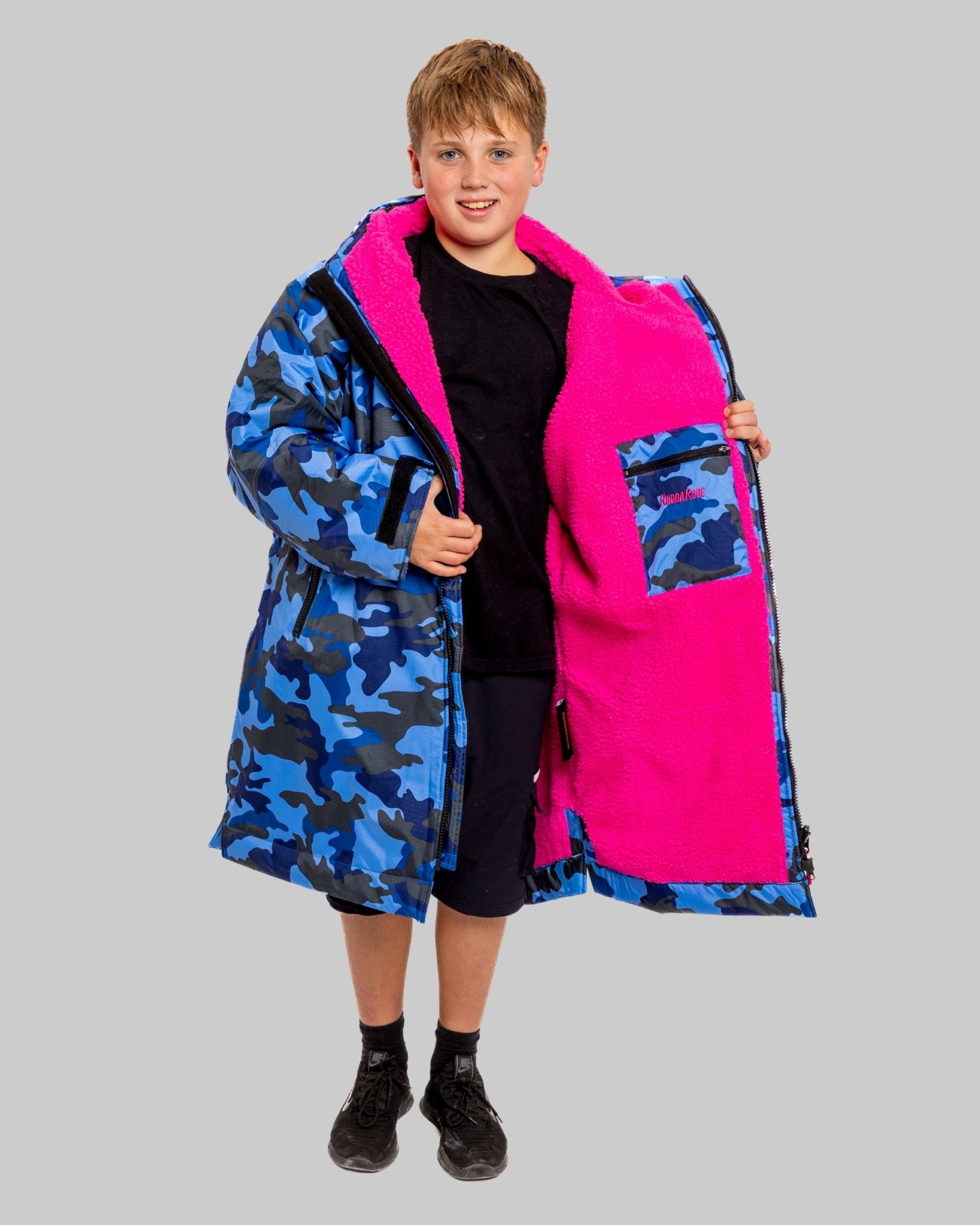Model wearing RuggaRobe blue camo change robe with pink fleece interior on grey background