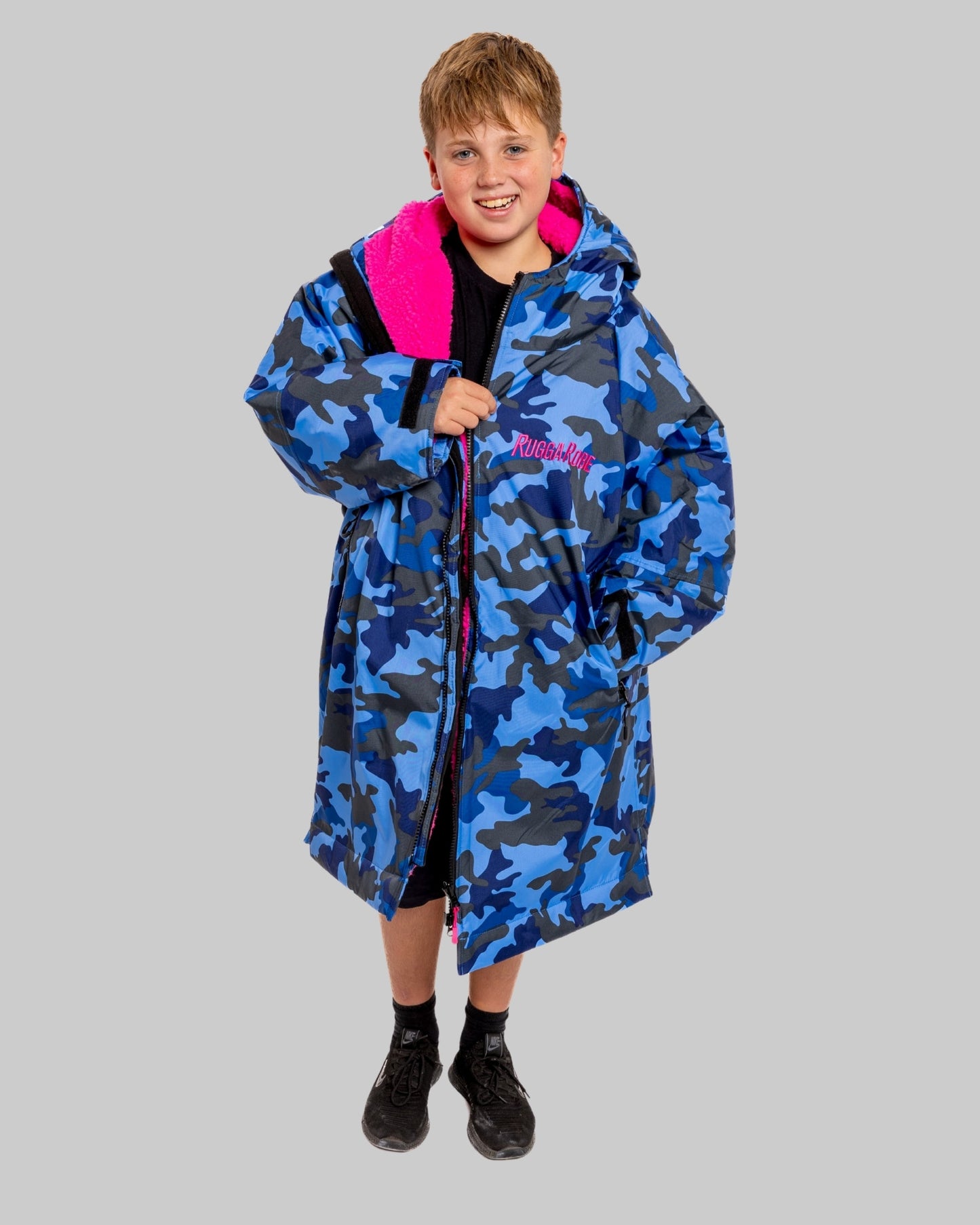 Model wearing RuggaRobe blue camo change robe with pink fleece interior on grey background