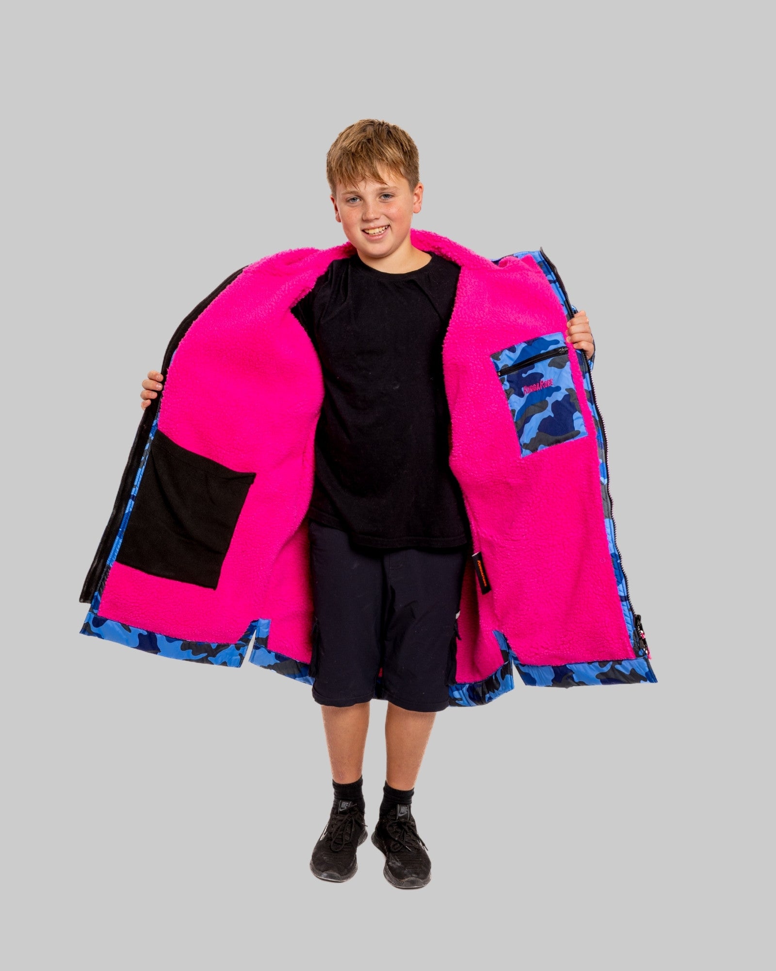 Model wearing RuggaRobe blue camo change robe with pink fleece interior on grey background