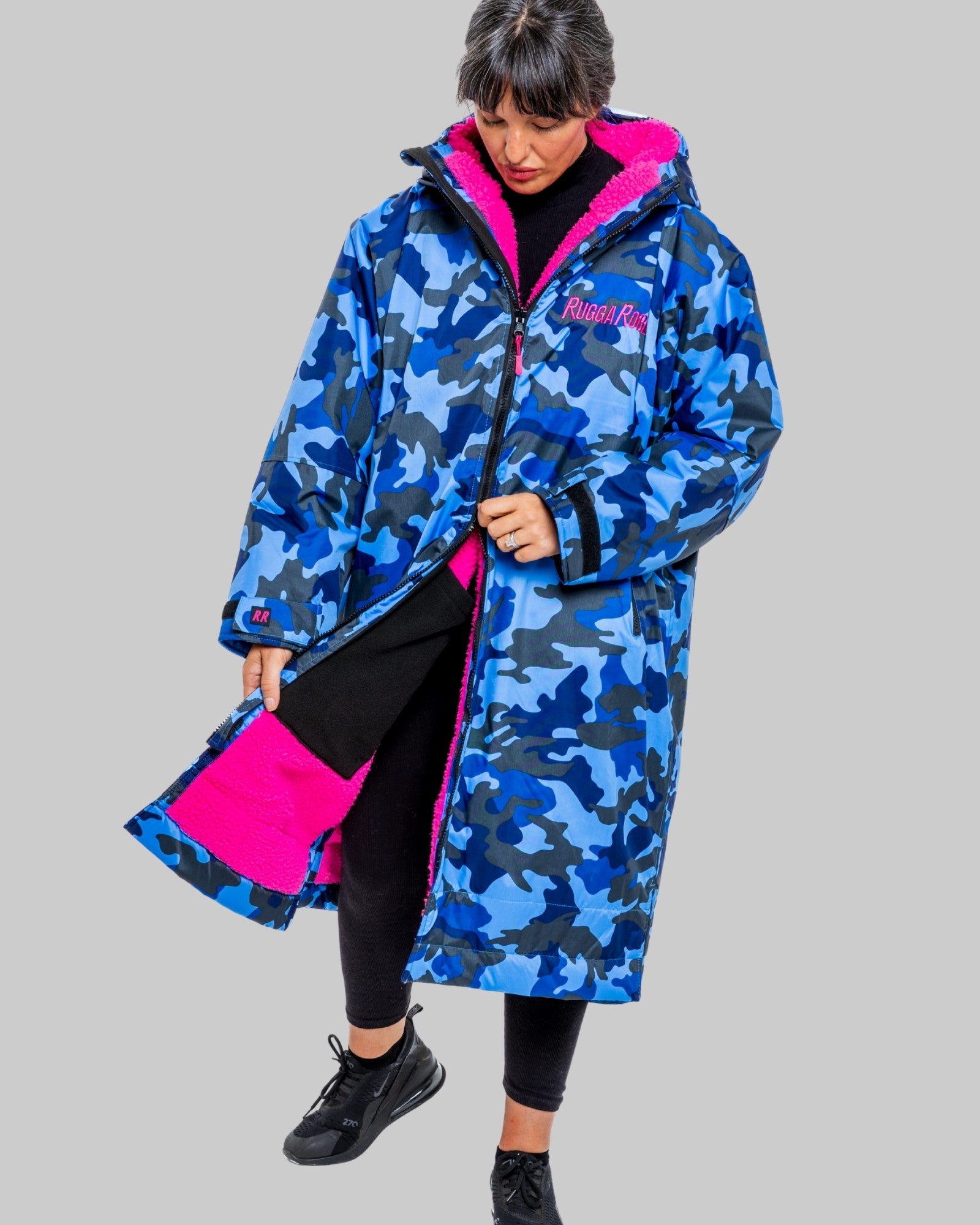 Person wearing a blue camouflage ruggarobe with pink accents on a gray background