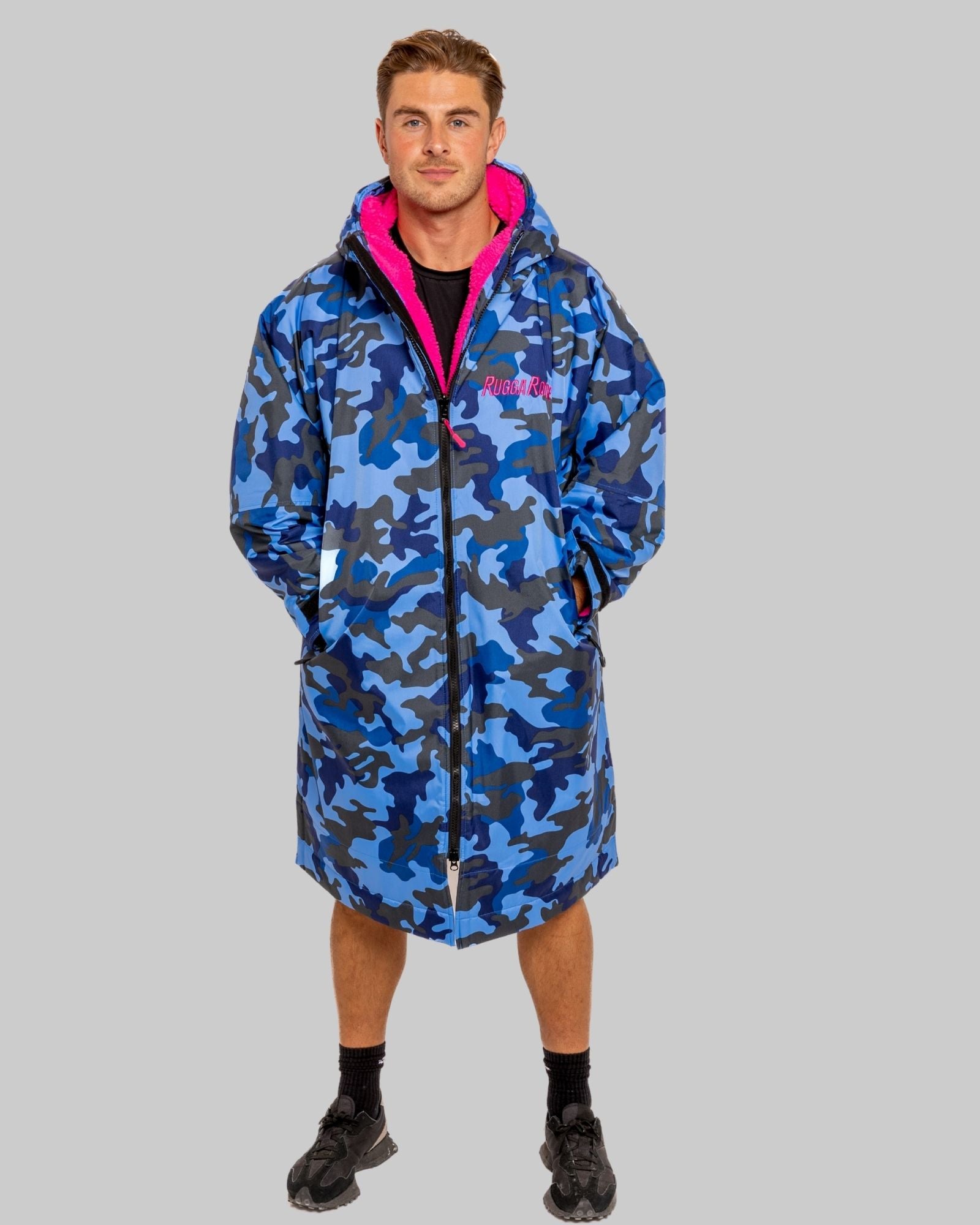 Person wearing a blue camouflage ruggarobe with pink accents on a gray background