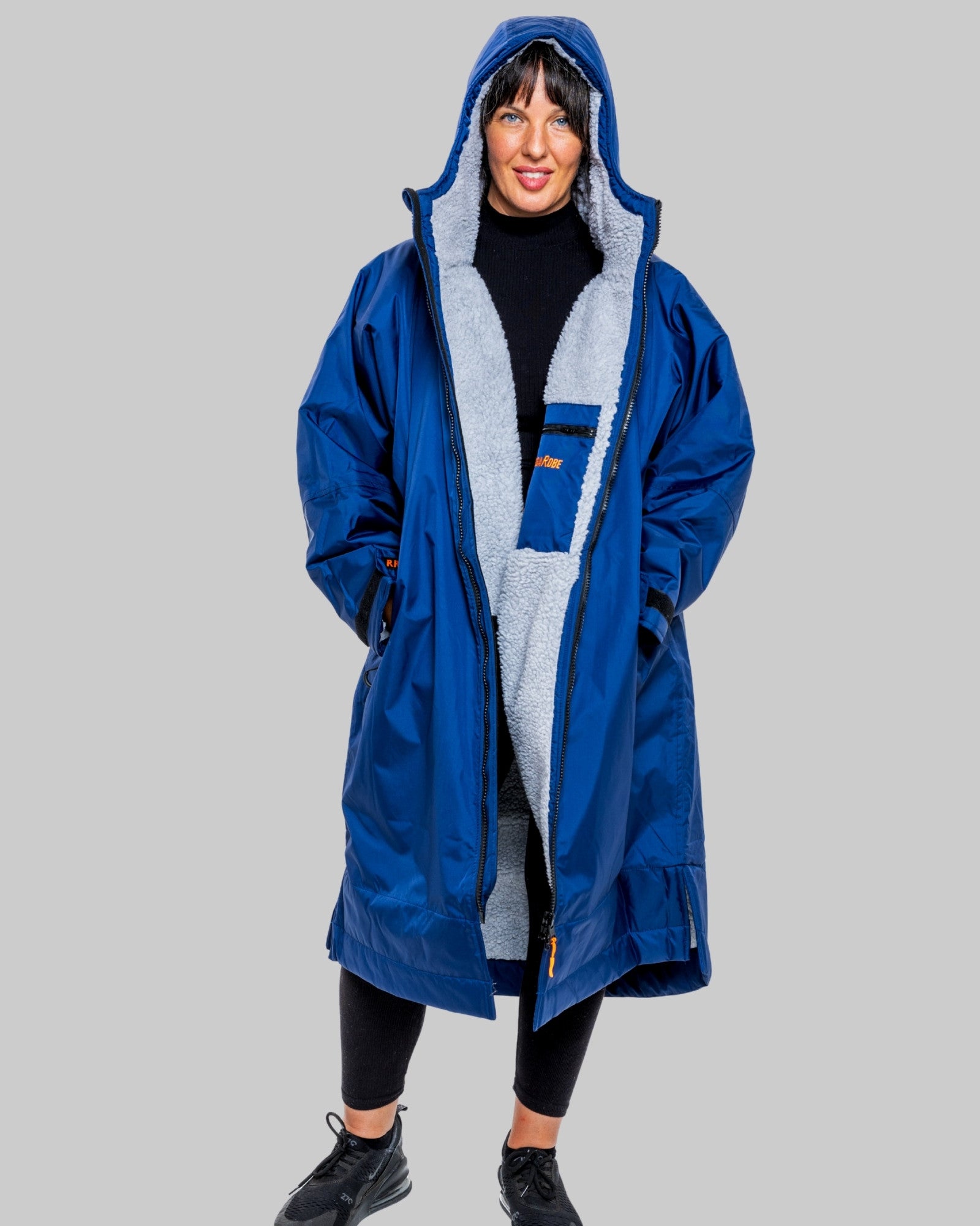 Man wearing a blue with grey fleece interior changerobe with visible brand logo on a grey background