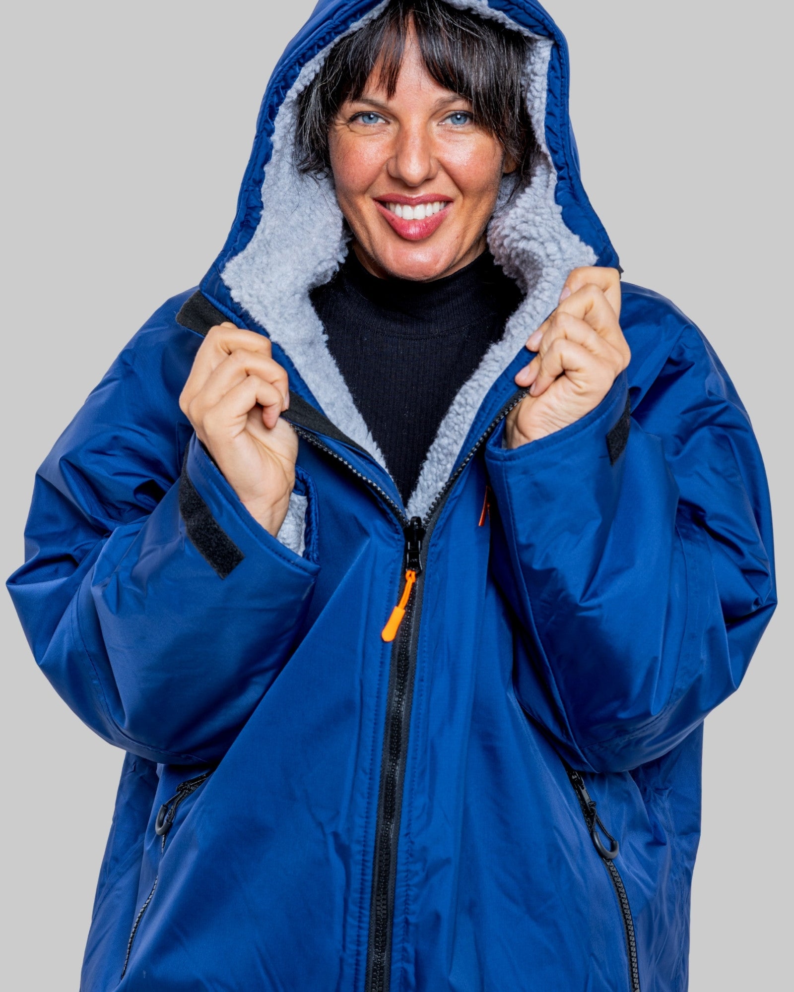 Woman wearing a blue with grey fleece interior changerobe on a grey background