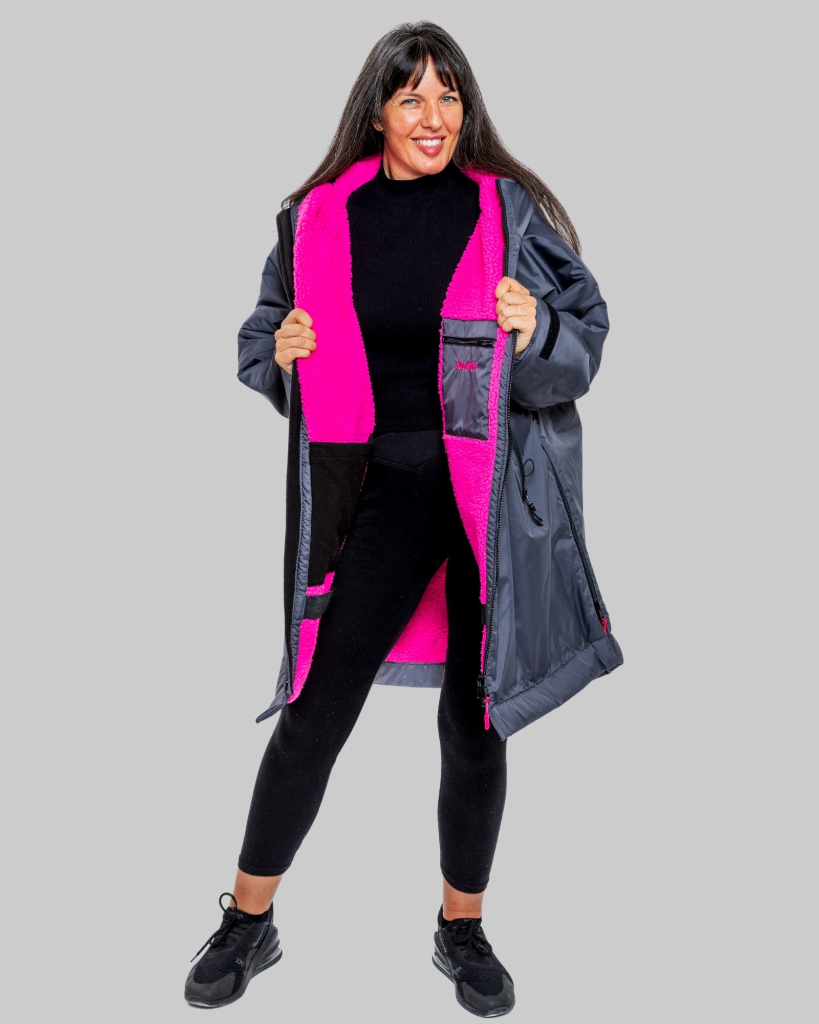 Model wearing RuggaRobe slate grey change robe with pink fleece interior on grey background