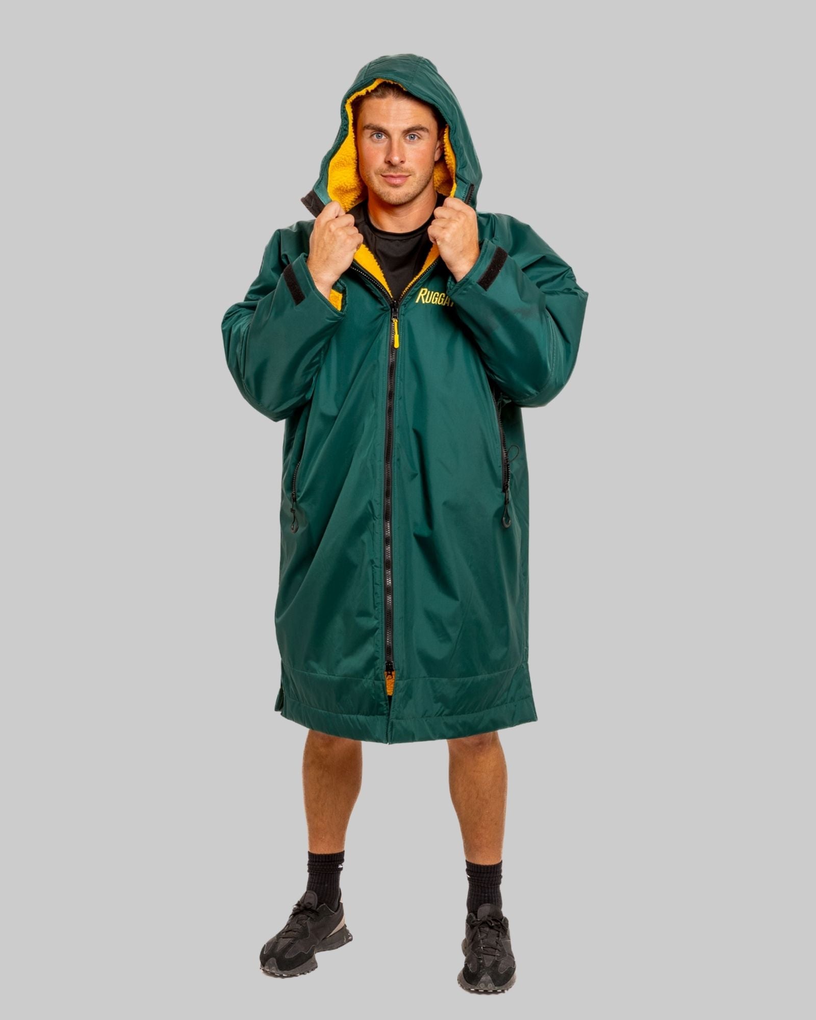 Person wearing a green with gold fleece change robe eith ruggarobe branding on a grey background