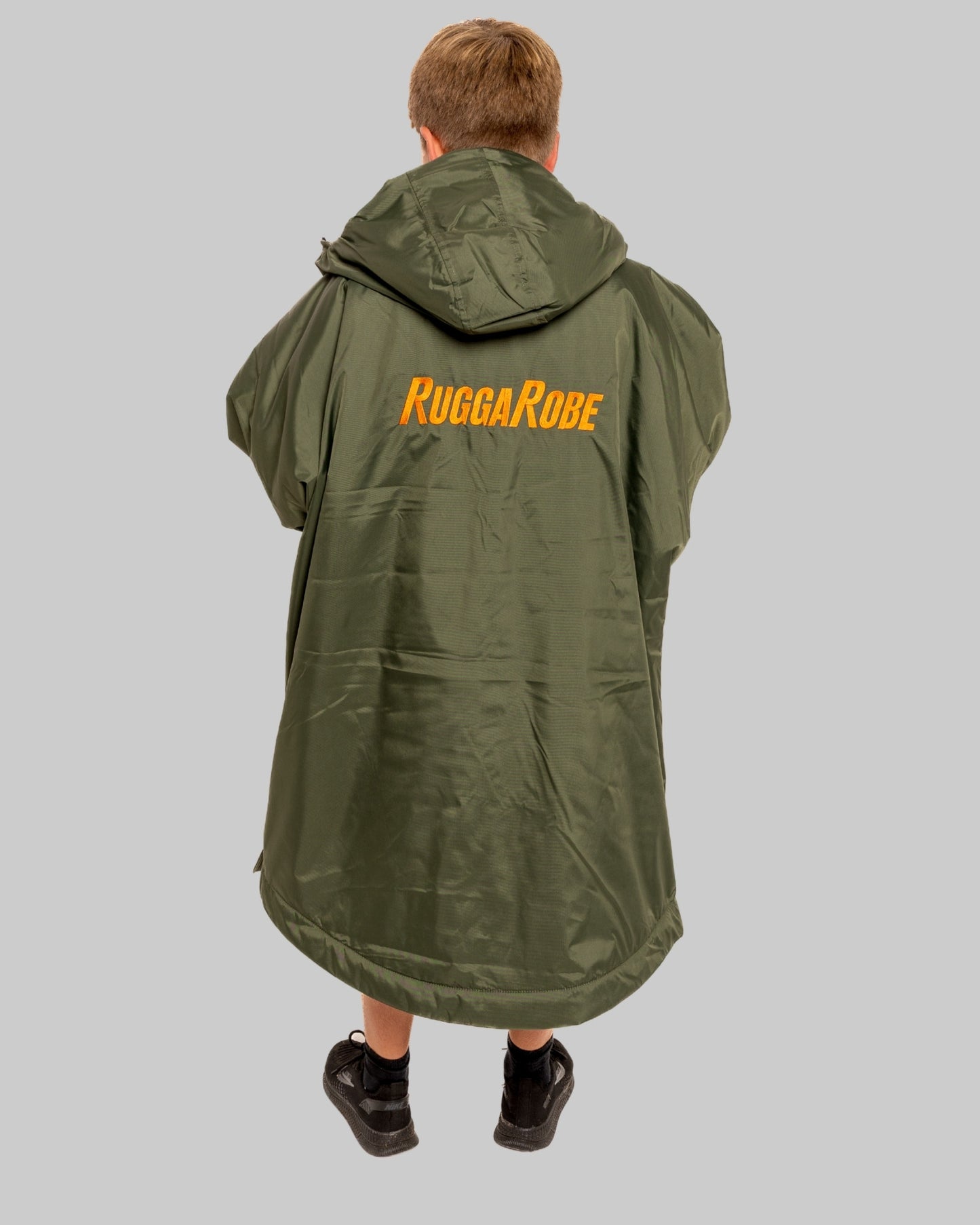 Model wearing RuggaRobe green change robe with black fleece interior on grey background