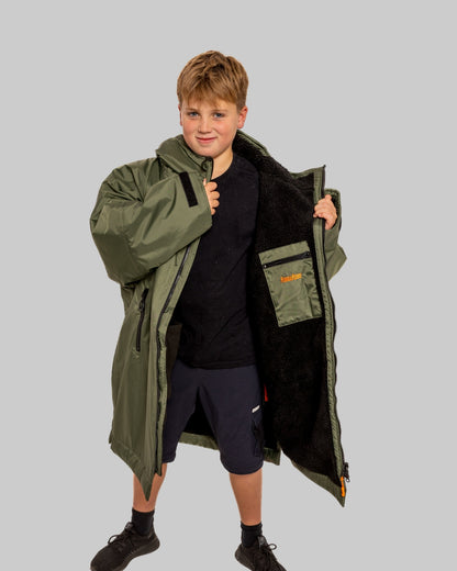 Model wearing RuggaRobe green change robe with black fleece interior on grey background