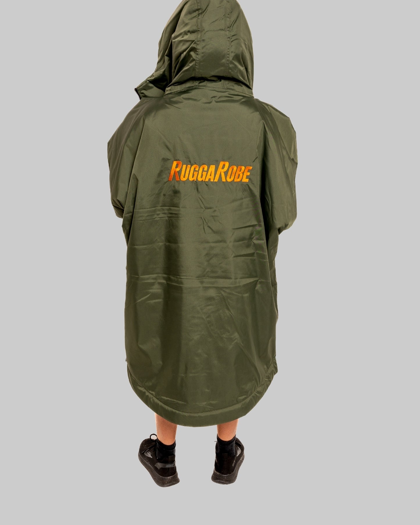 Model wearing RuggaRobe green change robe with black fleece interior on grey background