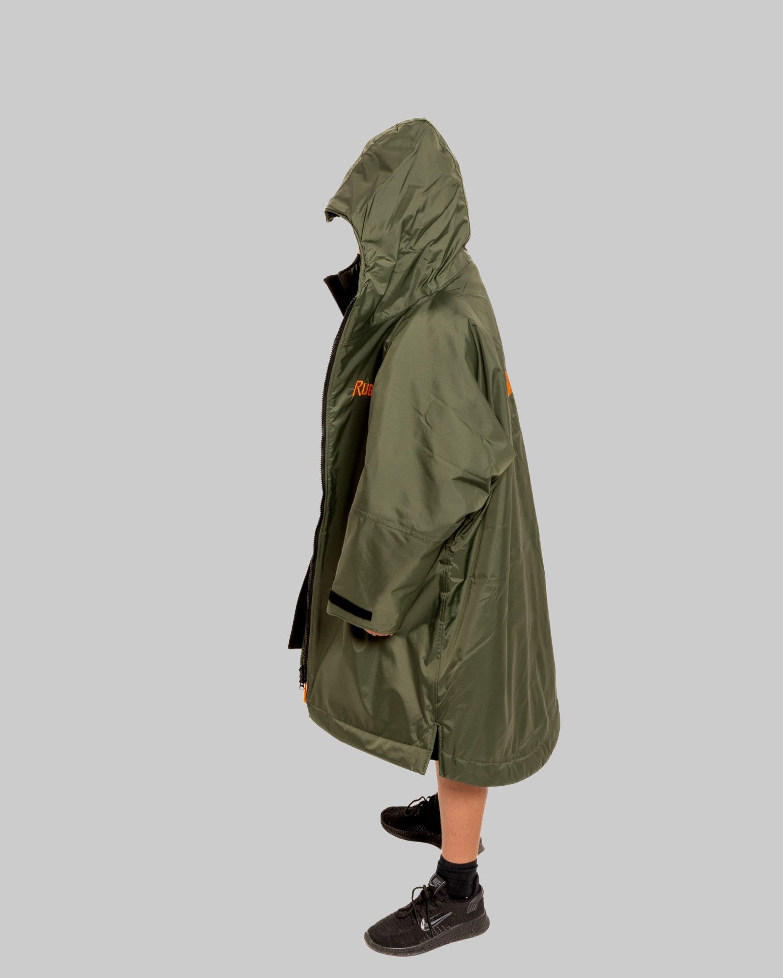 Model wearing RuggaRobe green change robe with black fleece interior on grey background