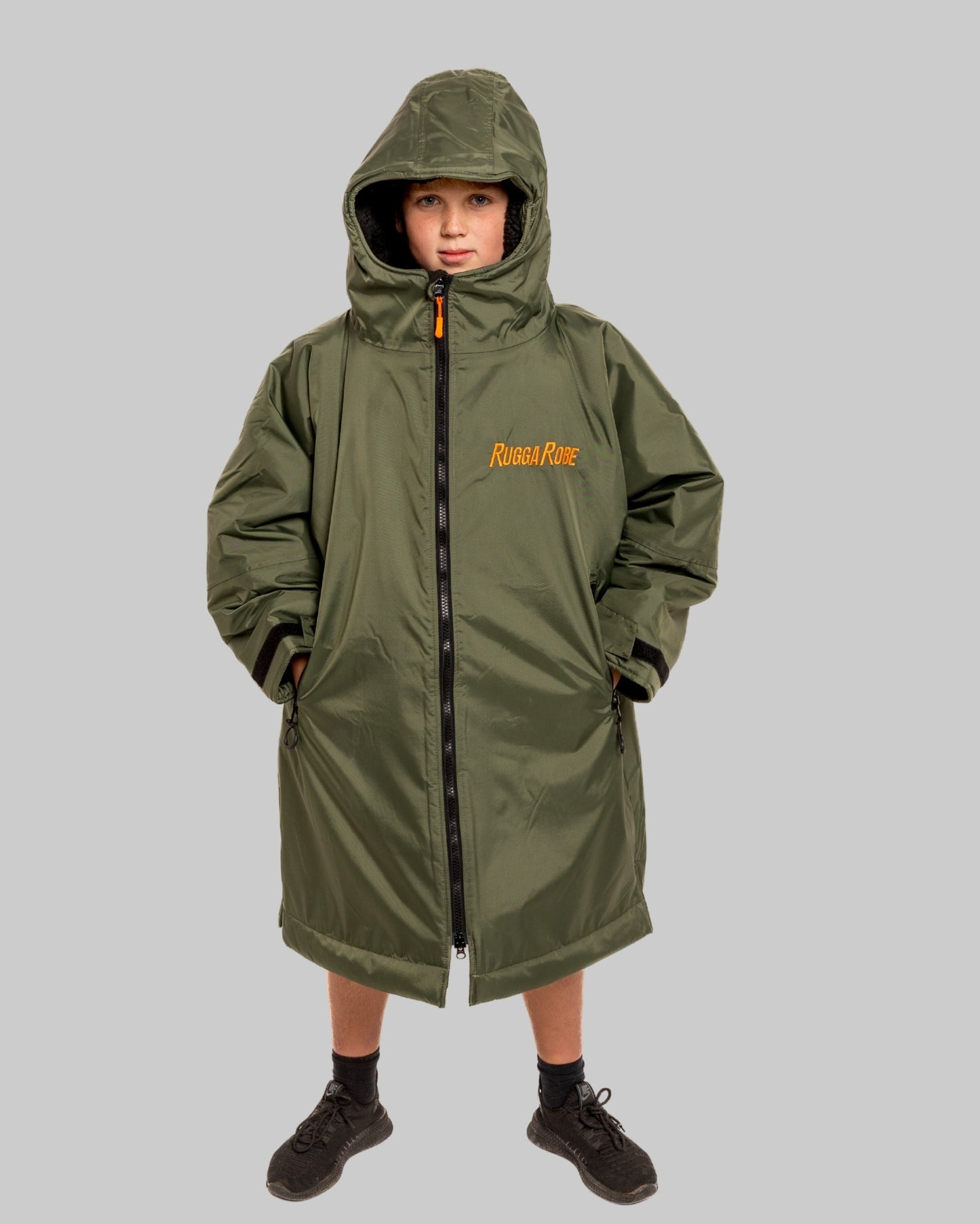 Model wearing RuggaRobe green change robe with black fleece interior on grey background