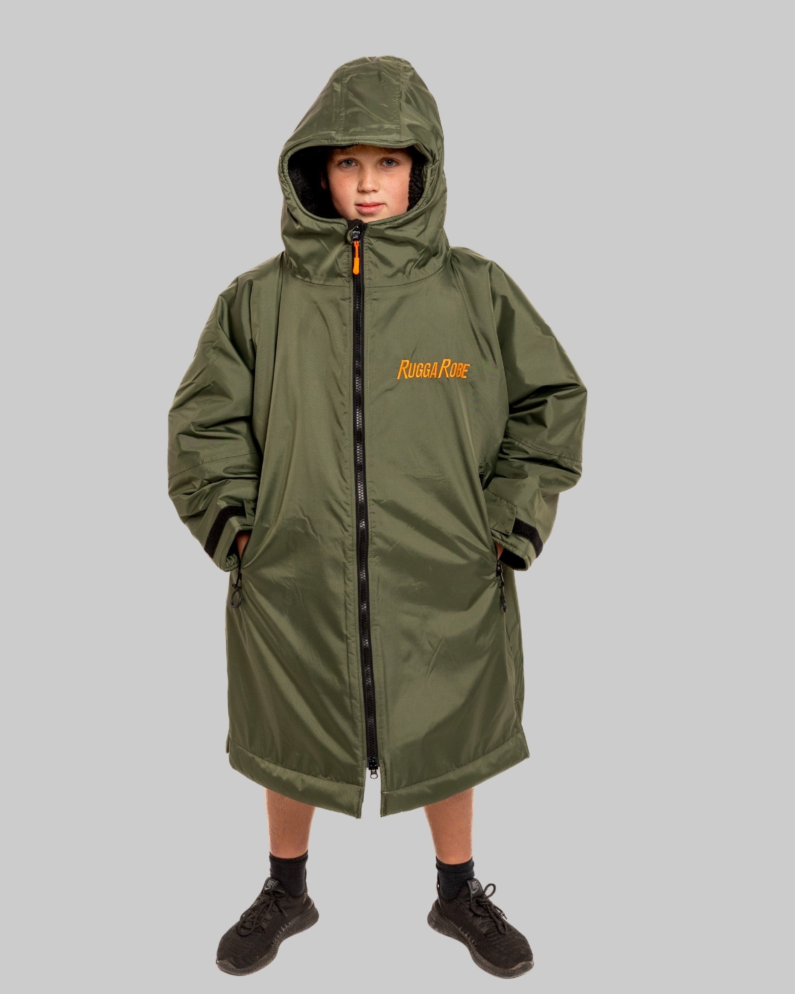 Model wearing RuggaRobe green change robe with black fleece interior on grey background