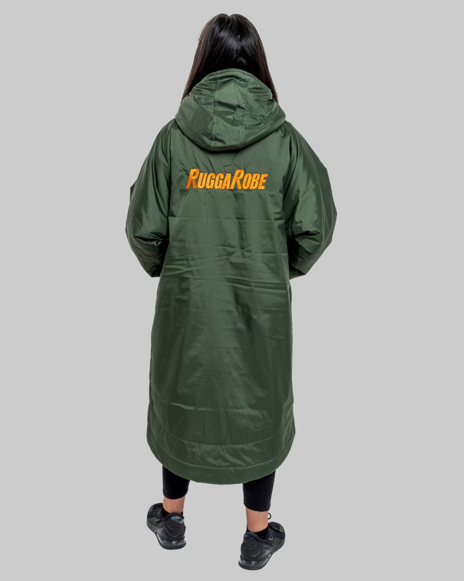 Person wearing a green coat with 'Rugga Robe' branding on the back against a grey background