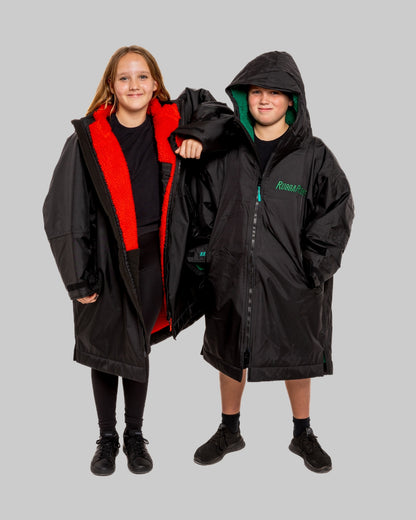 Two children wearing black with green and red interior accents on a gray background