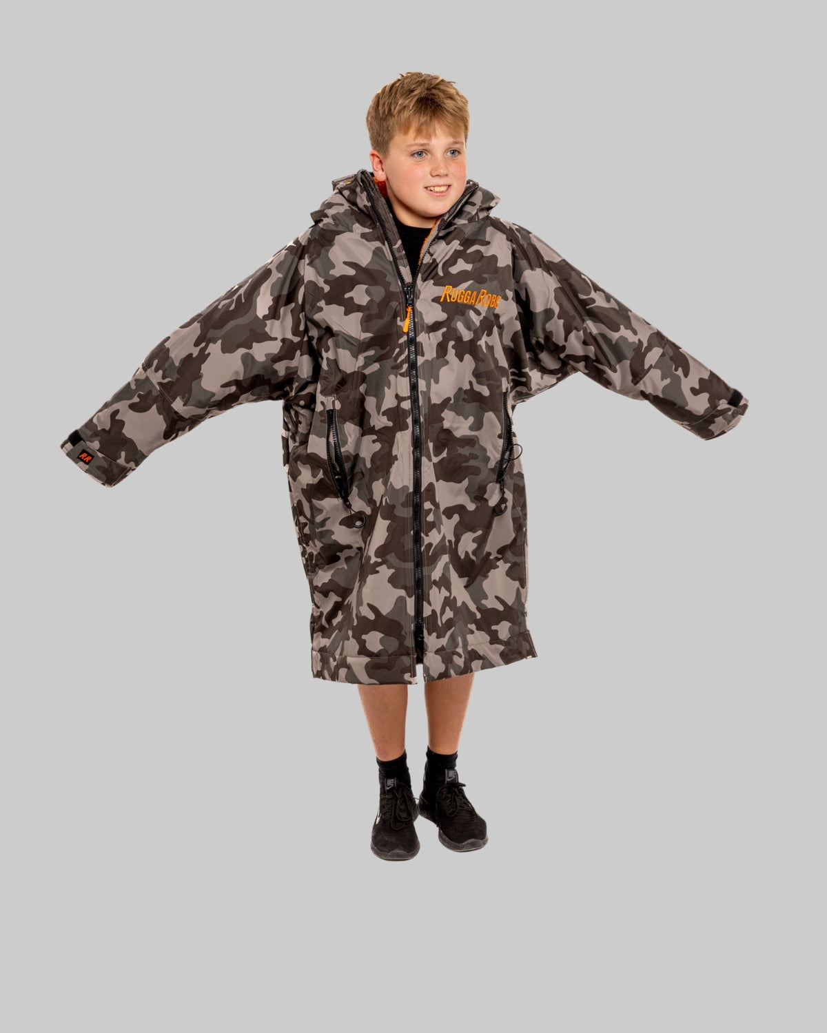 Model wearing RuggaRobe grey camo change robe with orange fleece interior on grey background