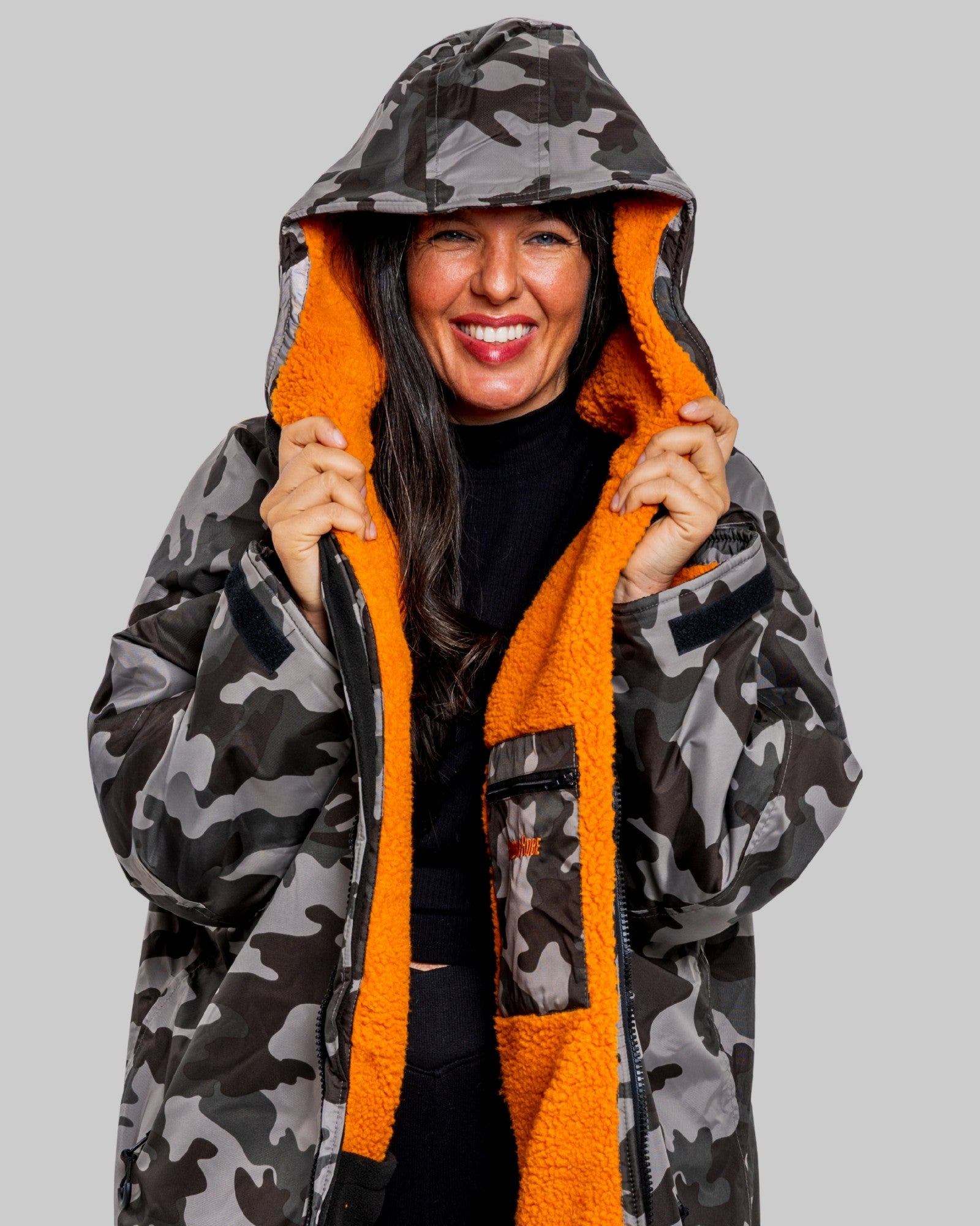 Model wearing RuggaRobe grey camo change robe with orange fleece interior on grey background