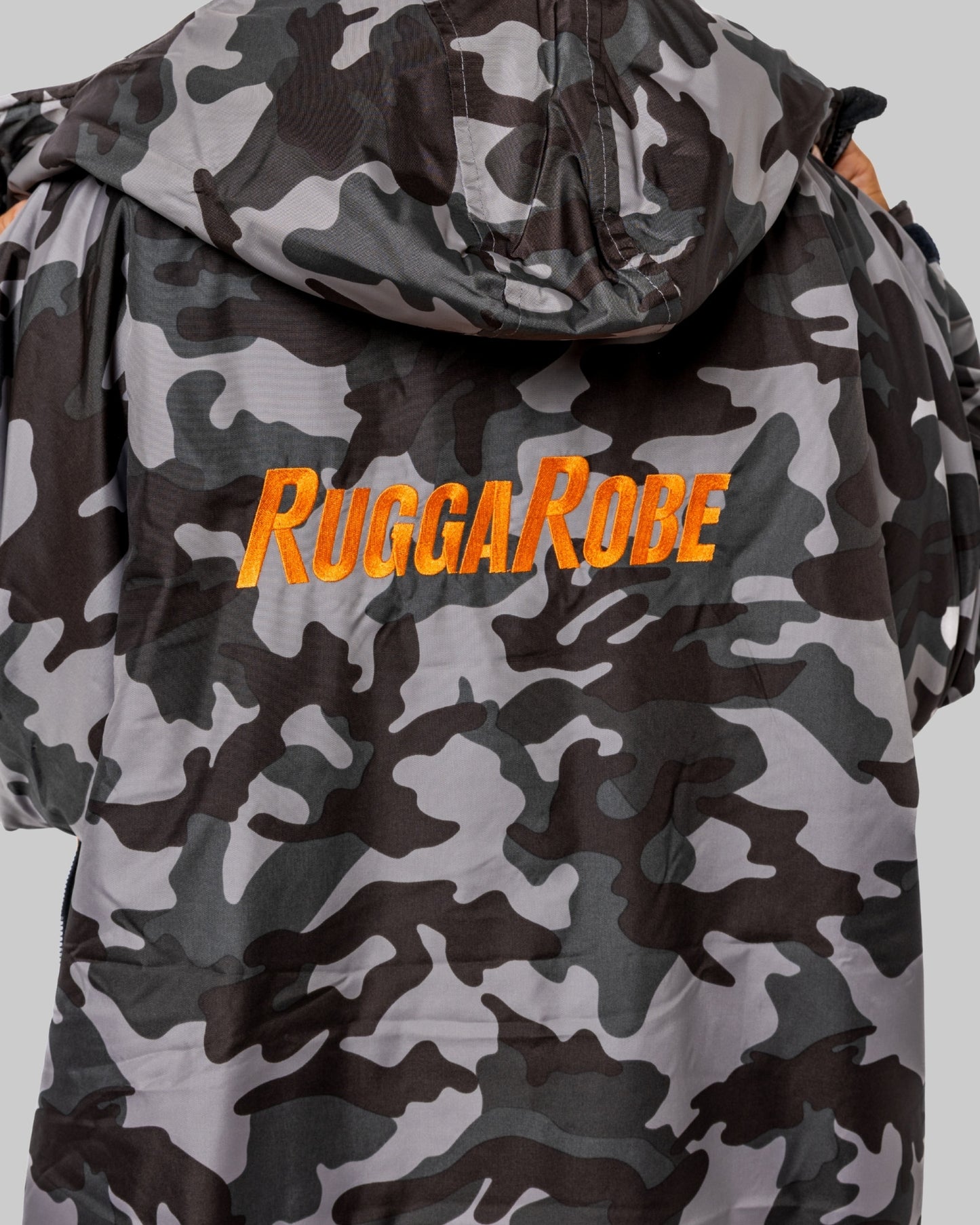 Model wearing RuggaRobe grey camo change robe with orange fleece interior on grey background