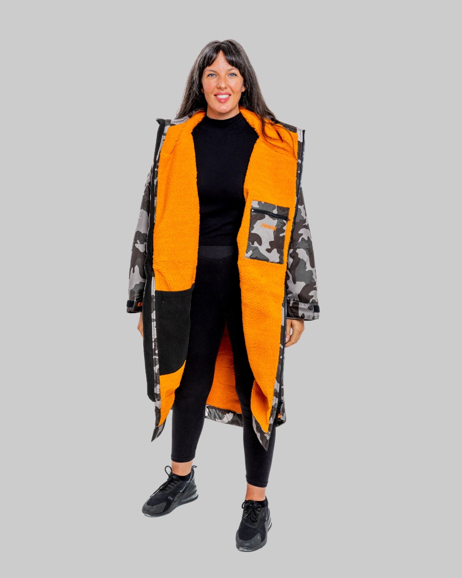 Model wearing RuggaRobe grey camo change robe with orange fleece interior on grey background