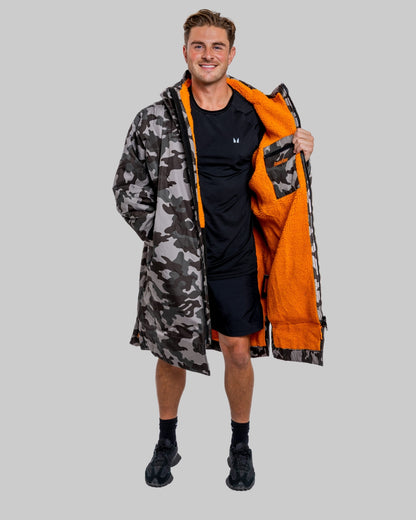 Model wearing RuggaRobe grey camo change robe with orange fleece interior on grey background