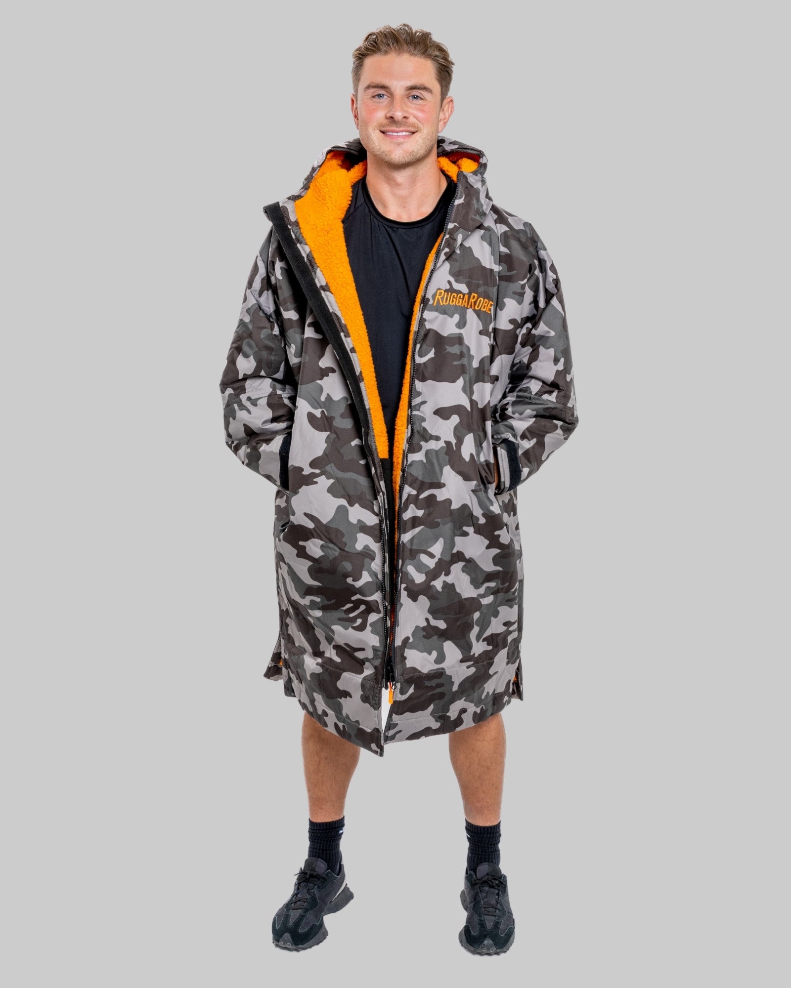 Model wearing RuggaRobe grey camo change robe with orange fleece interior on grey background