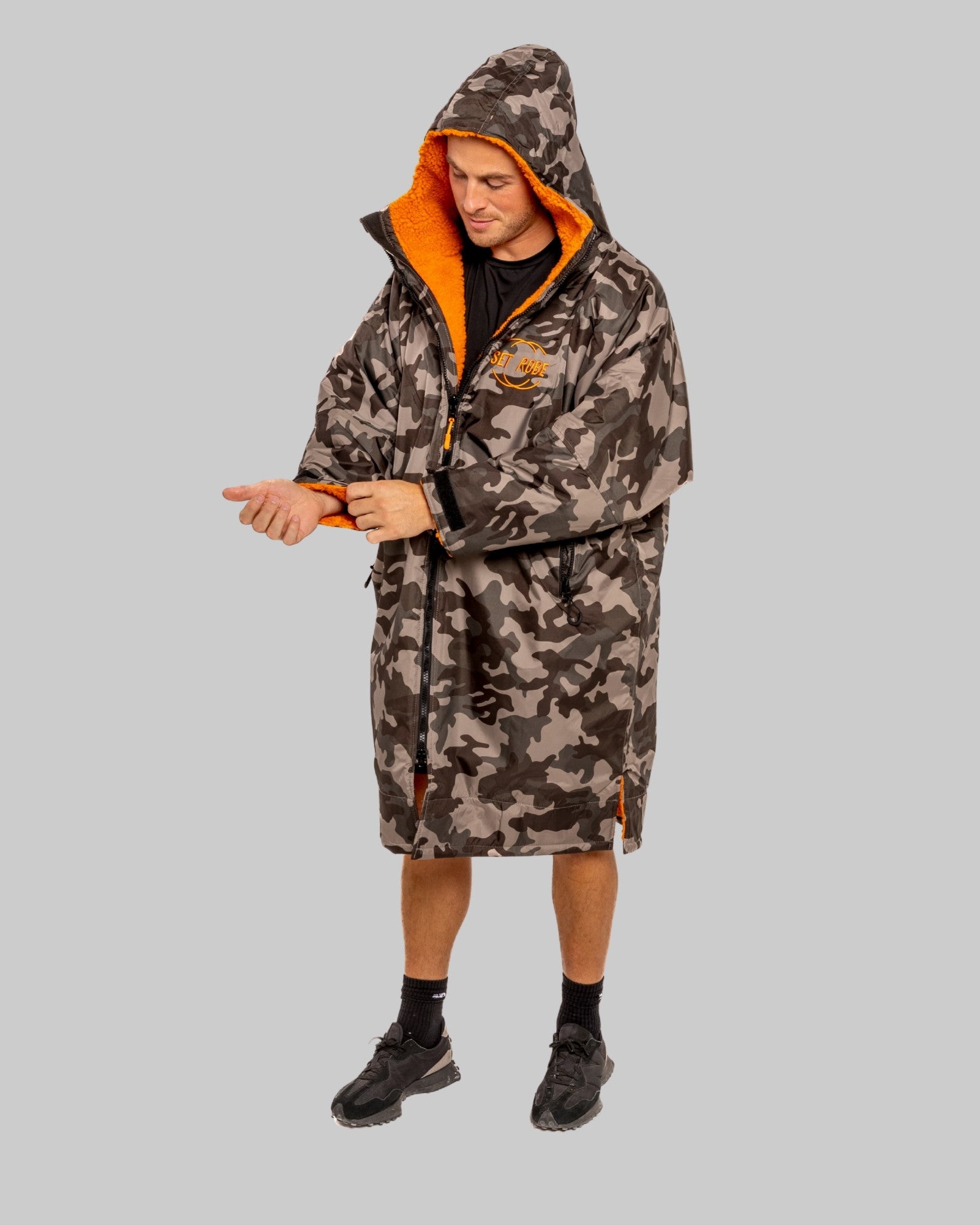 Model wearing RuggaRobe grey camo change robe with orange fleece interior on grey background