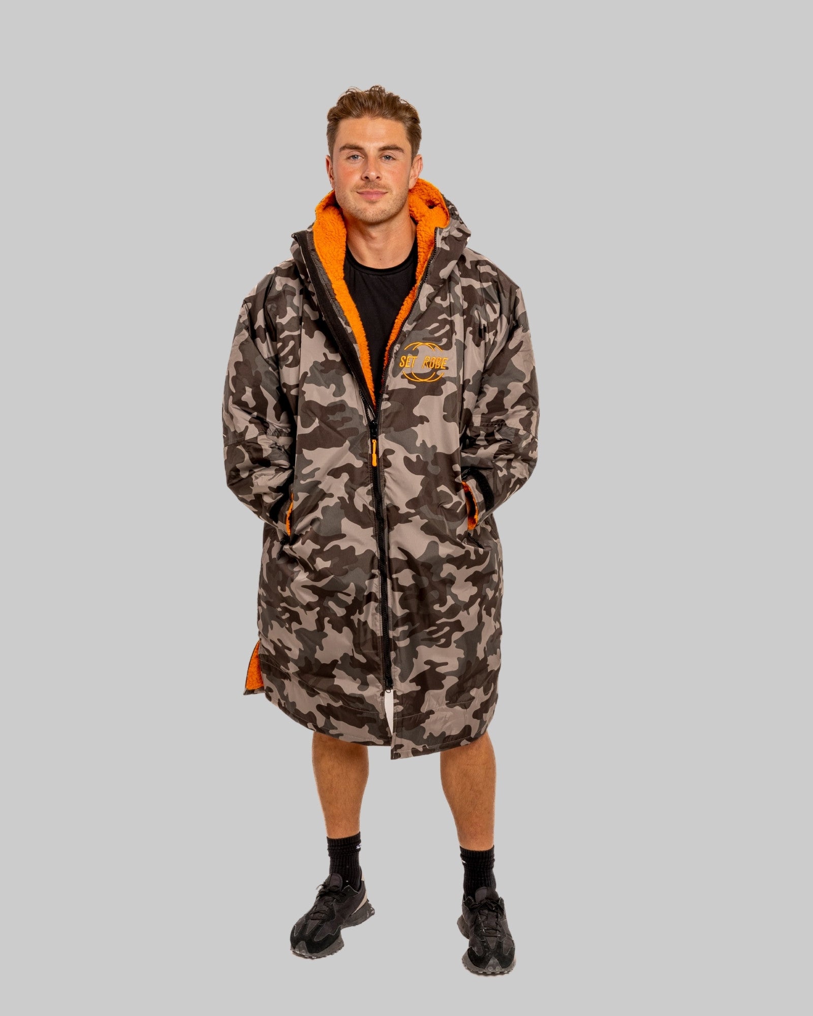 Model wearing RuggaRobe grey camo change robe with orange fleece interior on grey background