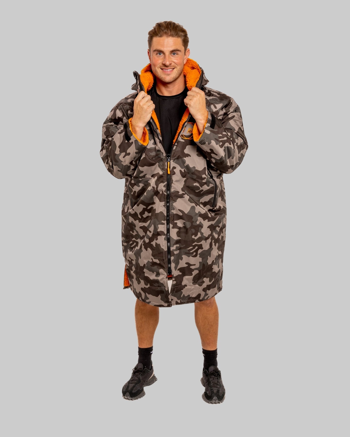 Model wearing RuggaRobe grey camo change robe with orange fleece interior on grey background