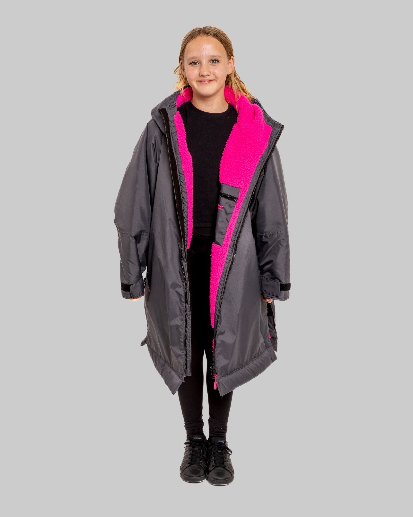 Model wearing RuggaRobe slate grey change robe with pink fleece interior on grey background