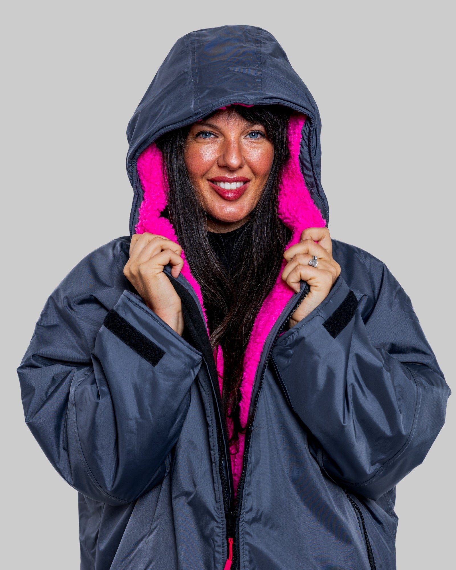 Model wearing RuggaRobe slate grey change robe with pink fleece interior on grey background