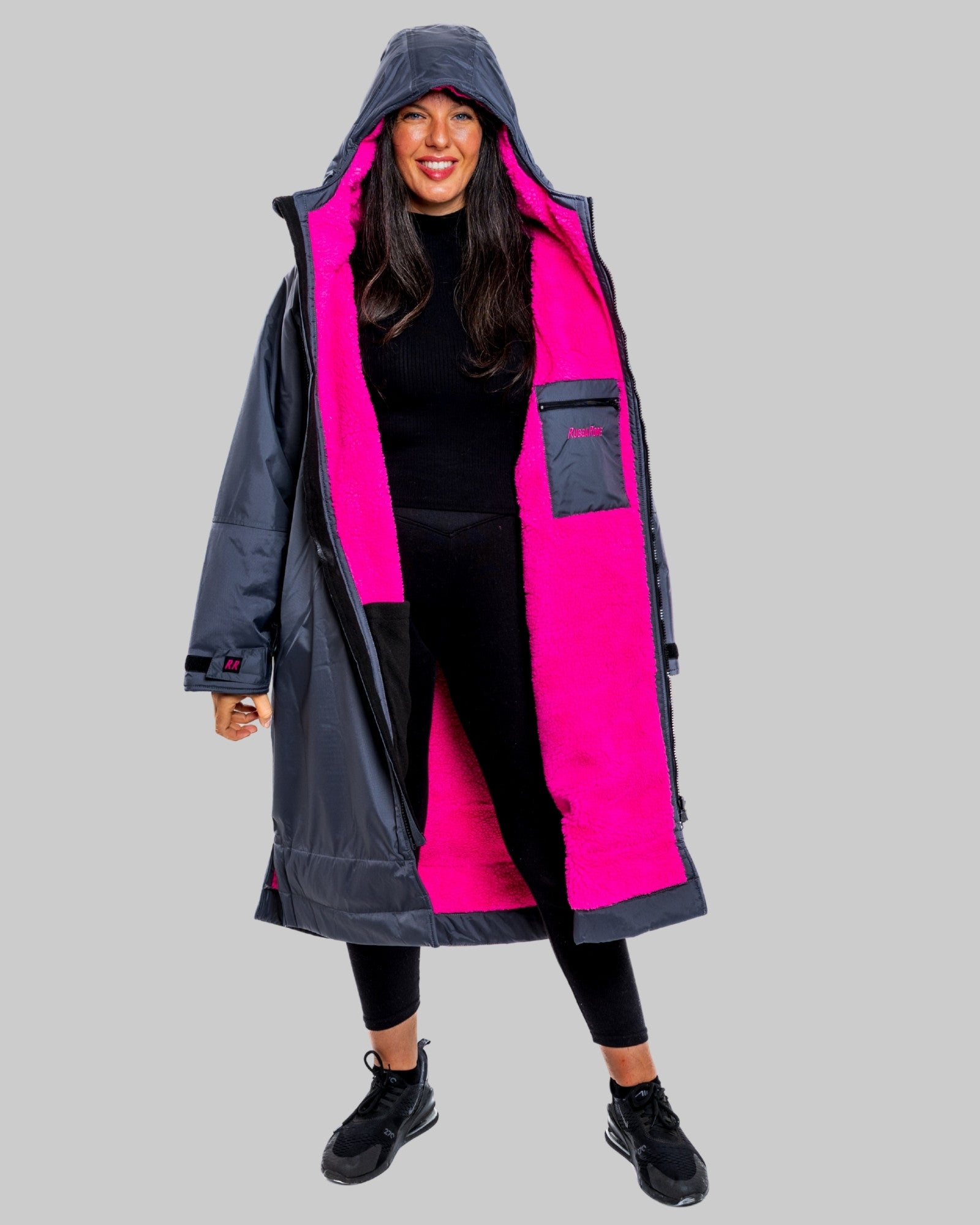 Model wearing RuggaRobe slate grey change robe with pink fleece interior on grey background