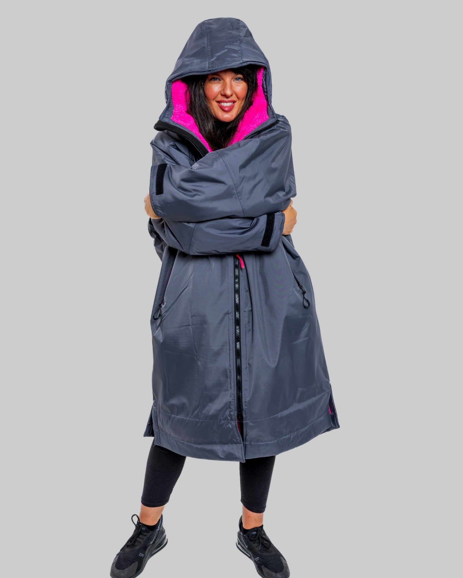Model wearing RuggaRobe slate grey change robe with pink fleece interior on grey background