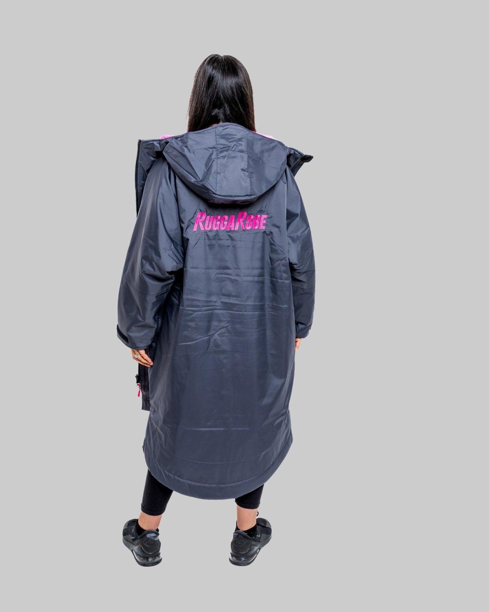 Model wearing RuggaRobe slate grey change robe with pink fleece interior on grey background