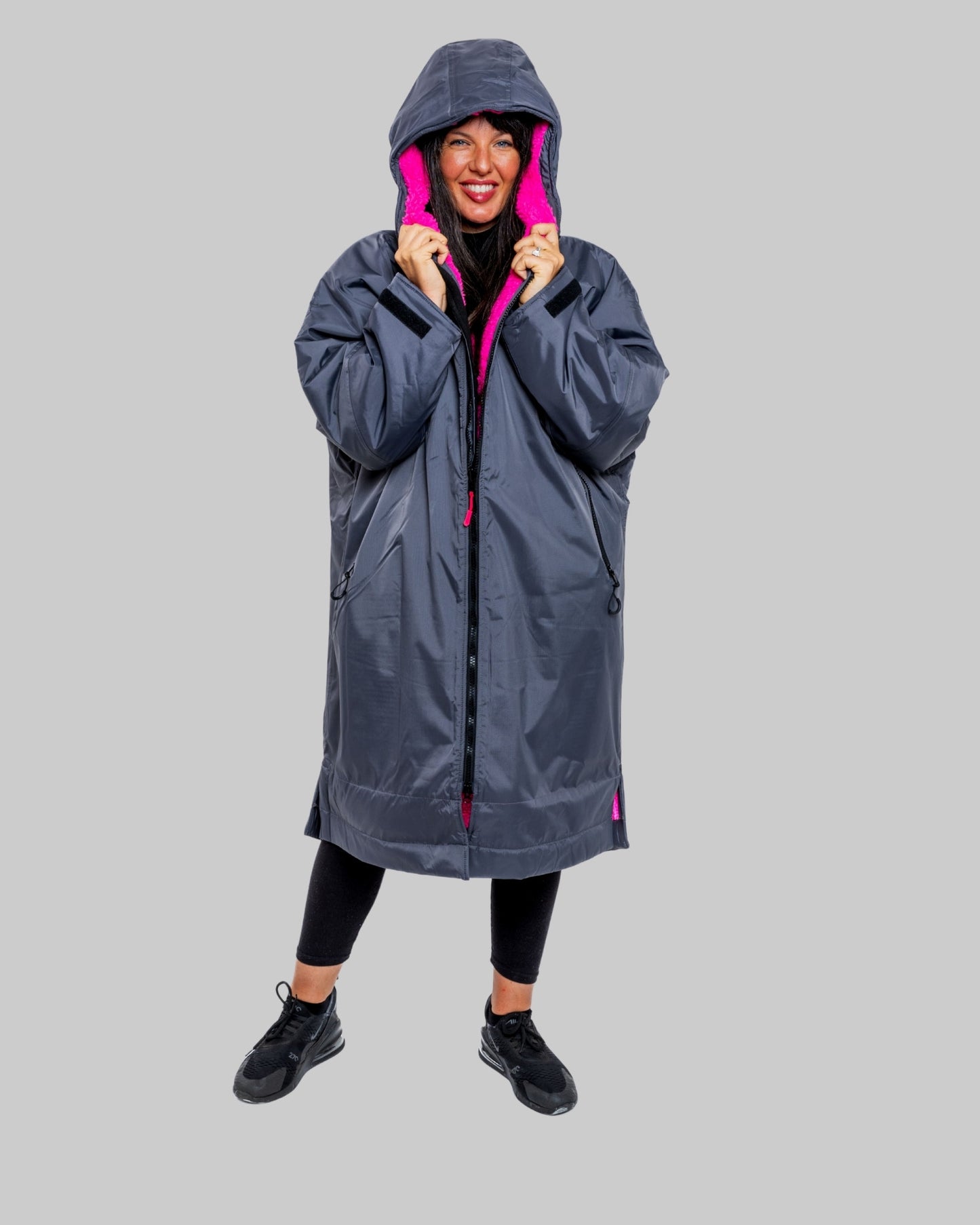 Model wearing RuggaRobe slate grey change robe with pink fleece interior on grey background