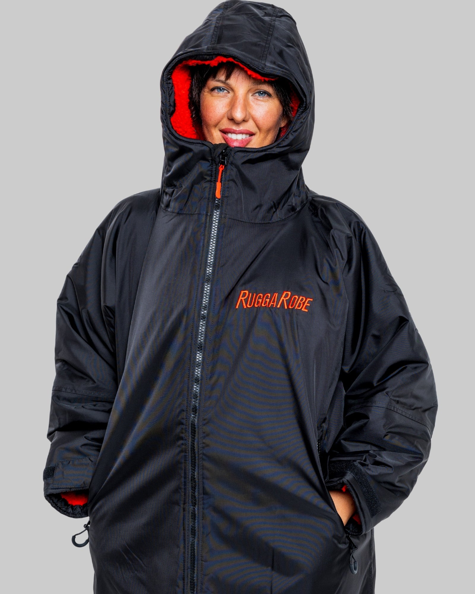 Person wearing a black changerobe with red interior and 'Rugga Robe' branding on a grey background