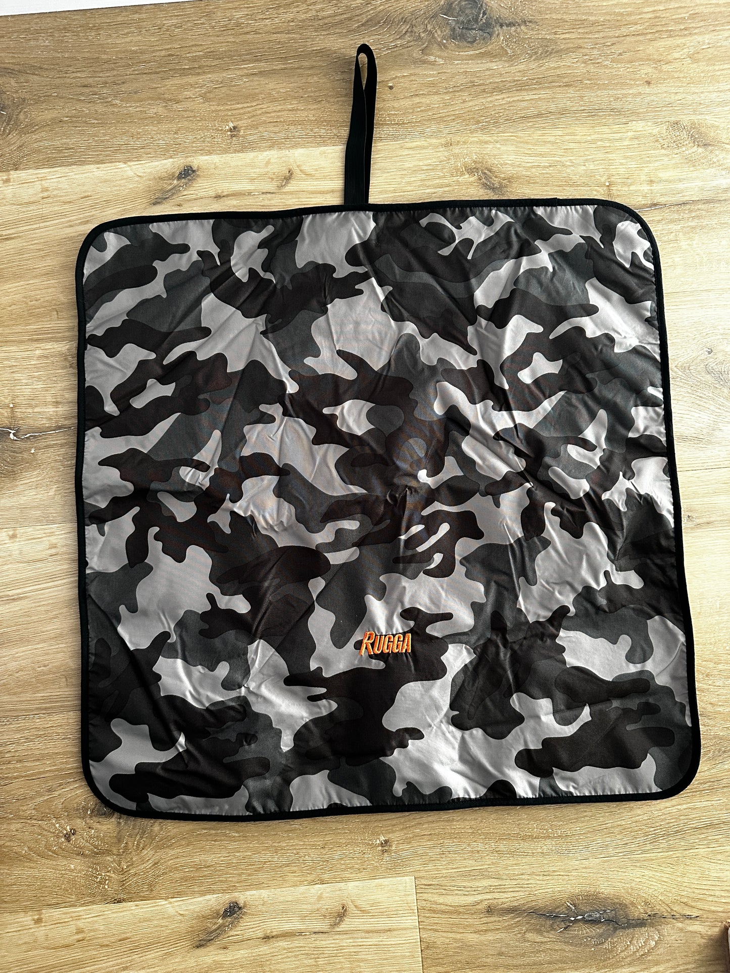 Rugga robe camouflage-patterned mat with a brand logo on a wooden floor