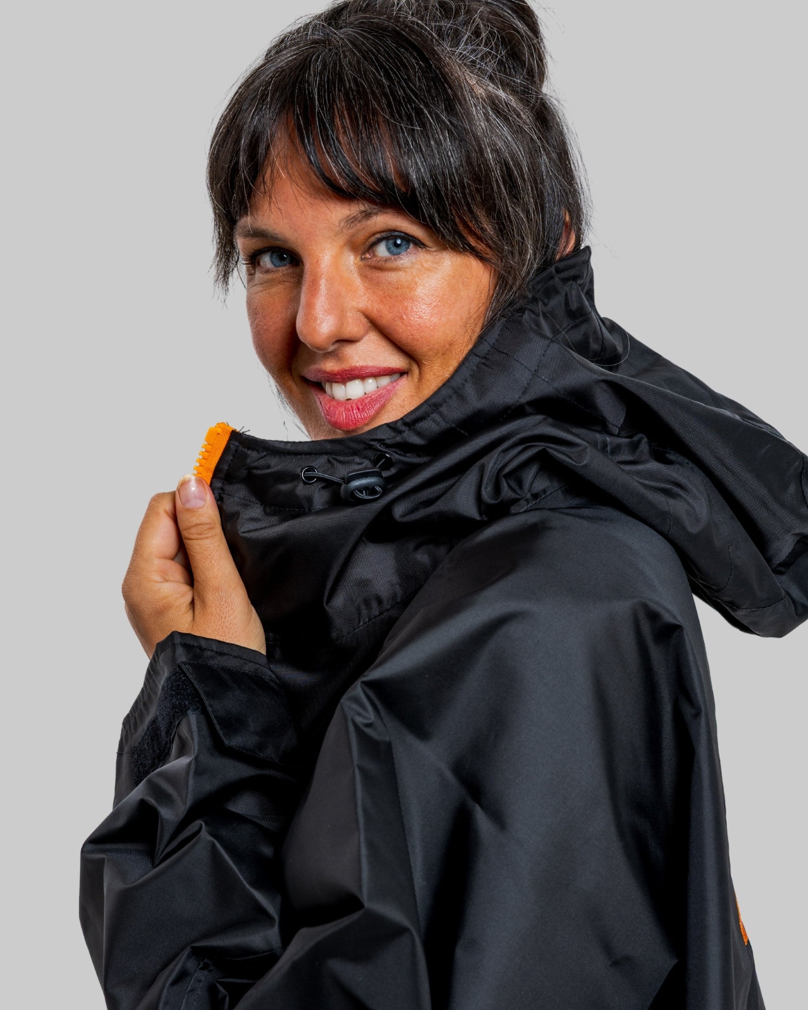 Woman wearing a black rugga robe change robe with a grey background