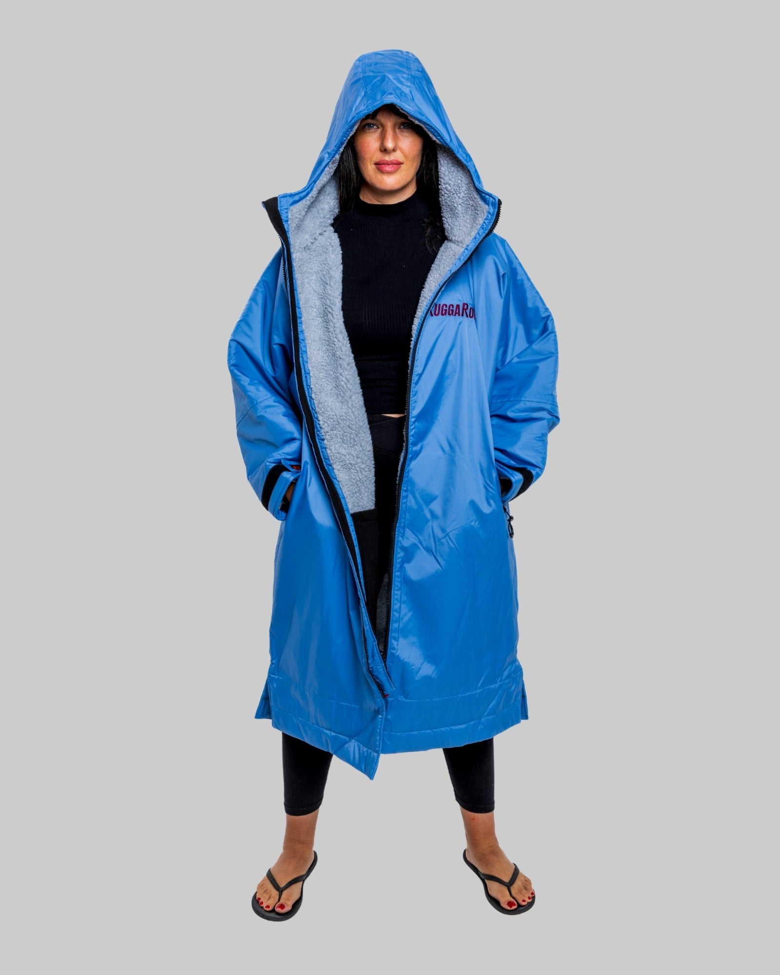 Model wearing a pale blue with grey feece  ruggarobe on a gray background