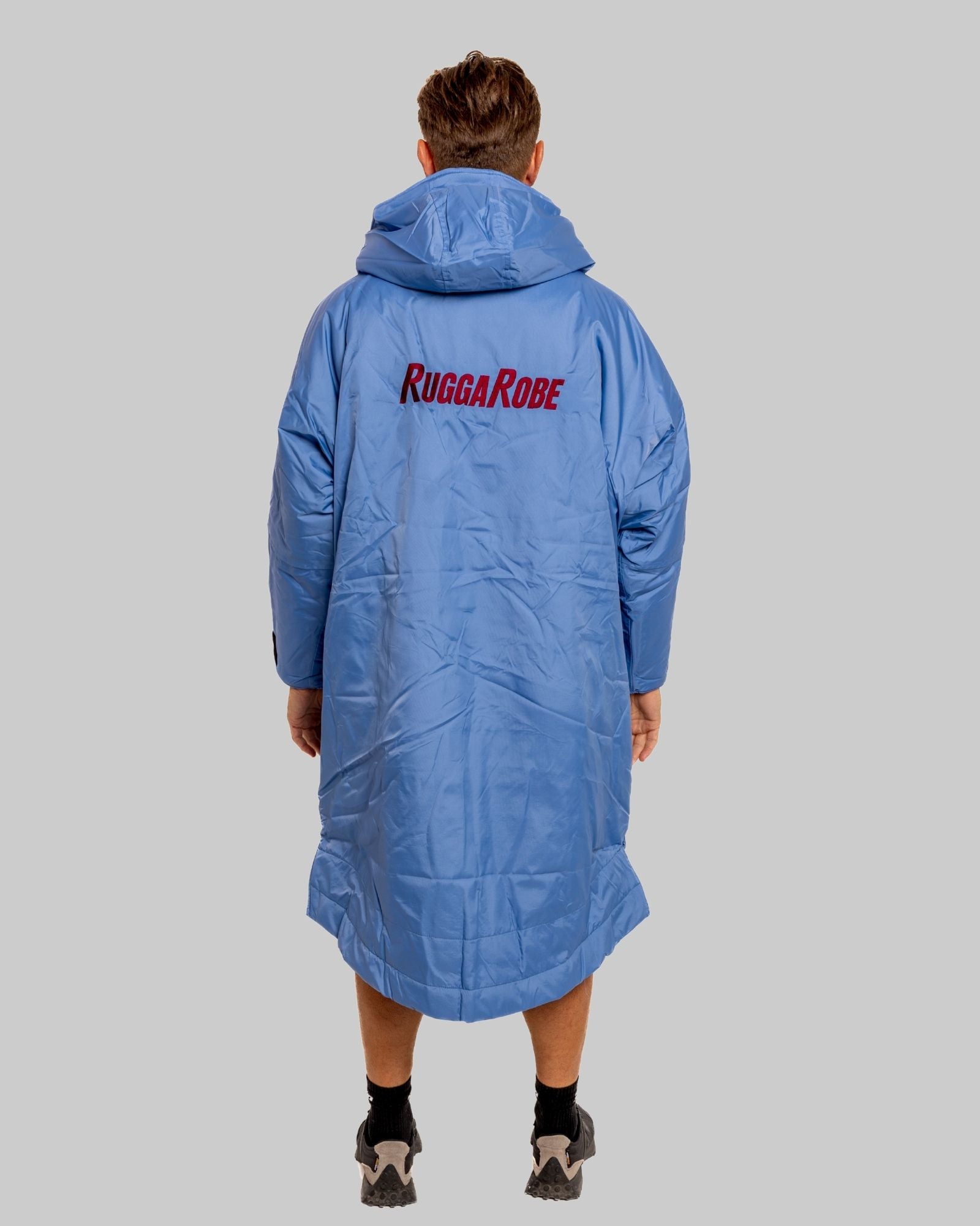 Person wearing a blue Rugga Robe on a gray background