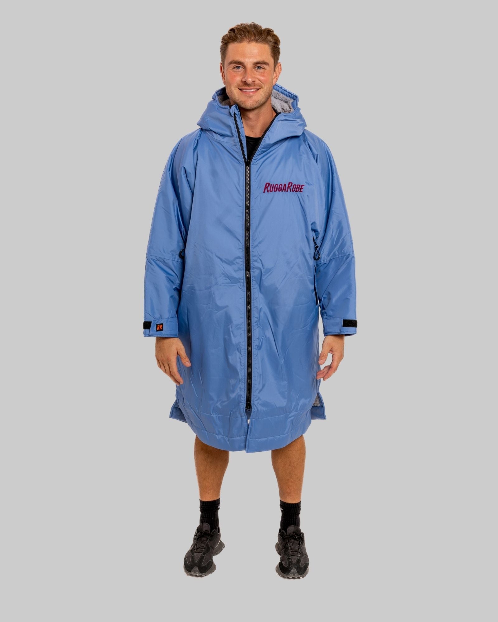 Model wearing a pale blue with grey feece  ruggarobe on a gray background