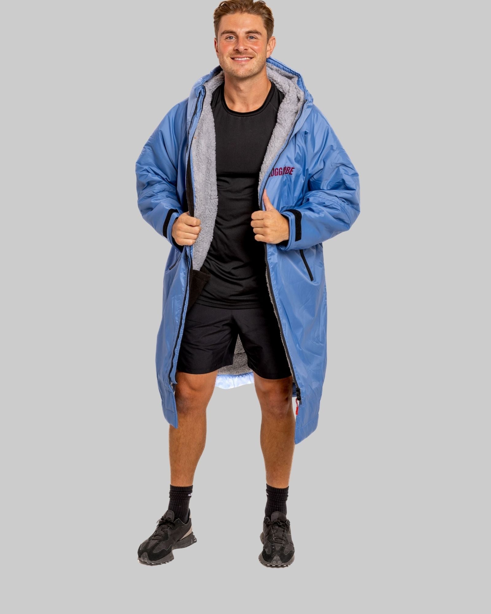 Model wearing a pale blue with grey feece  ruggarobe on a gray background