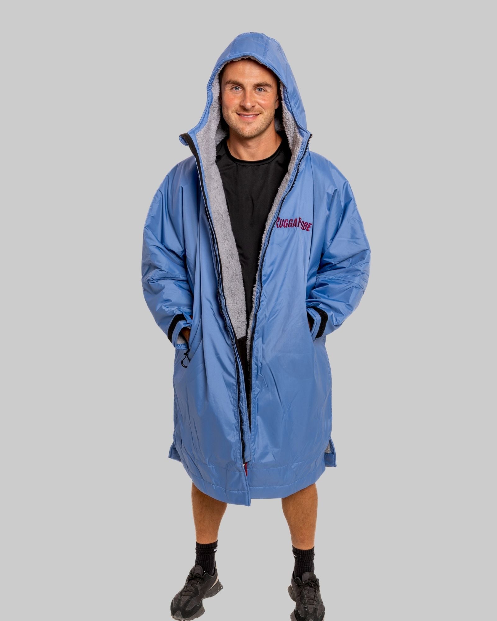 Model wearing a pale blue with grey feece  ruggarobe on a gray background