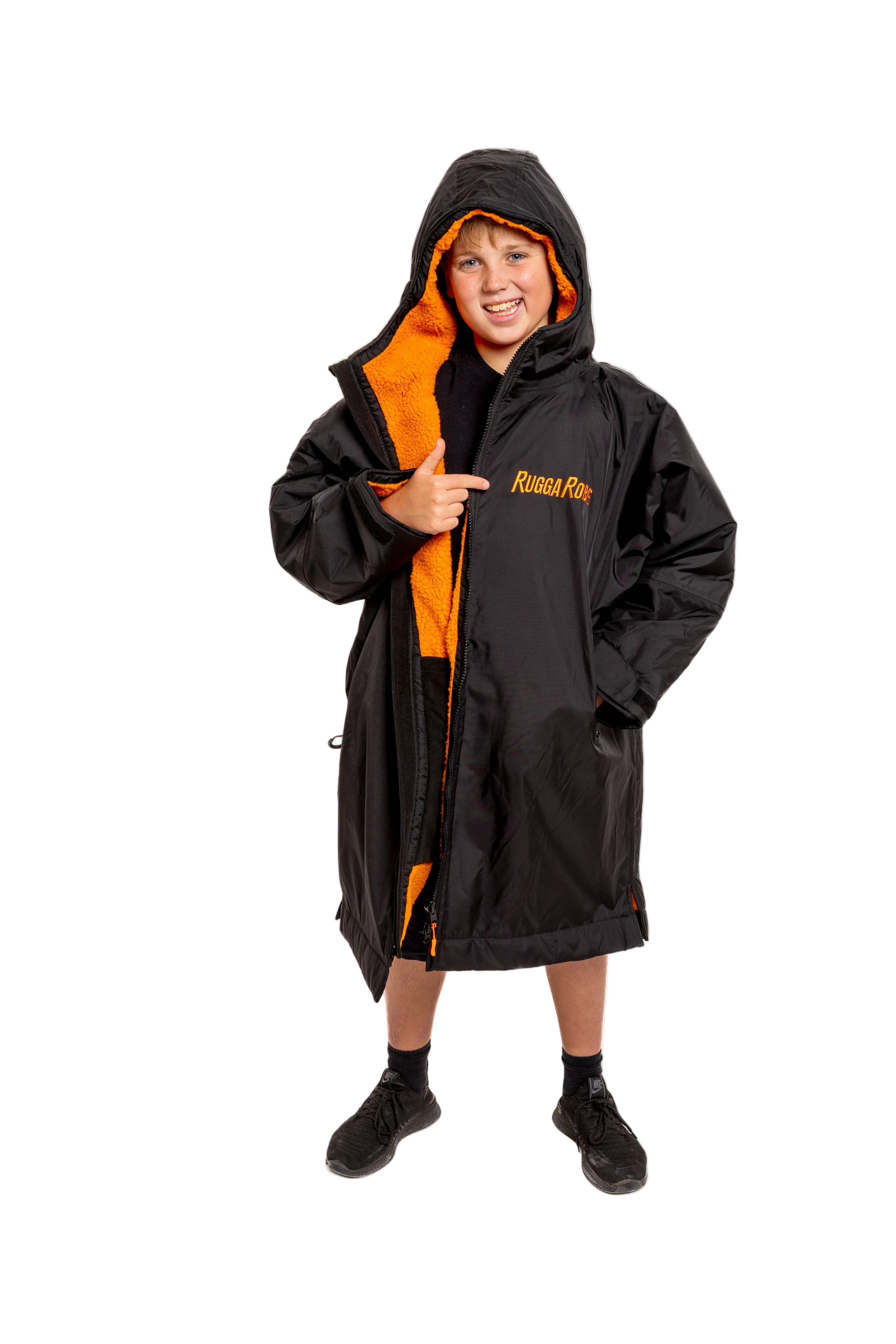 Model wearing RuggaRobe black change robe with orange fleece interior on grey background