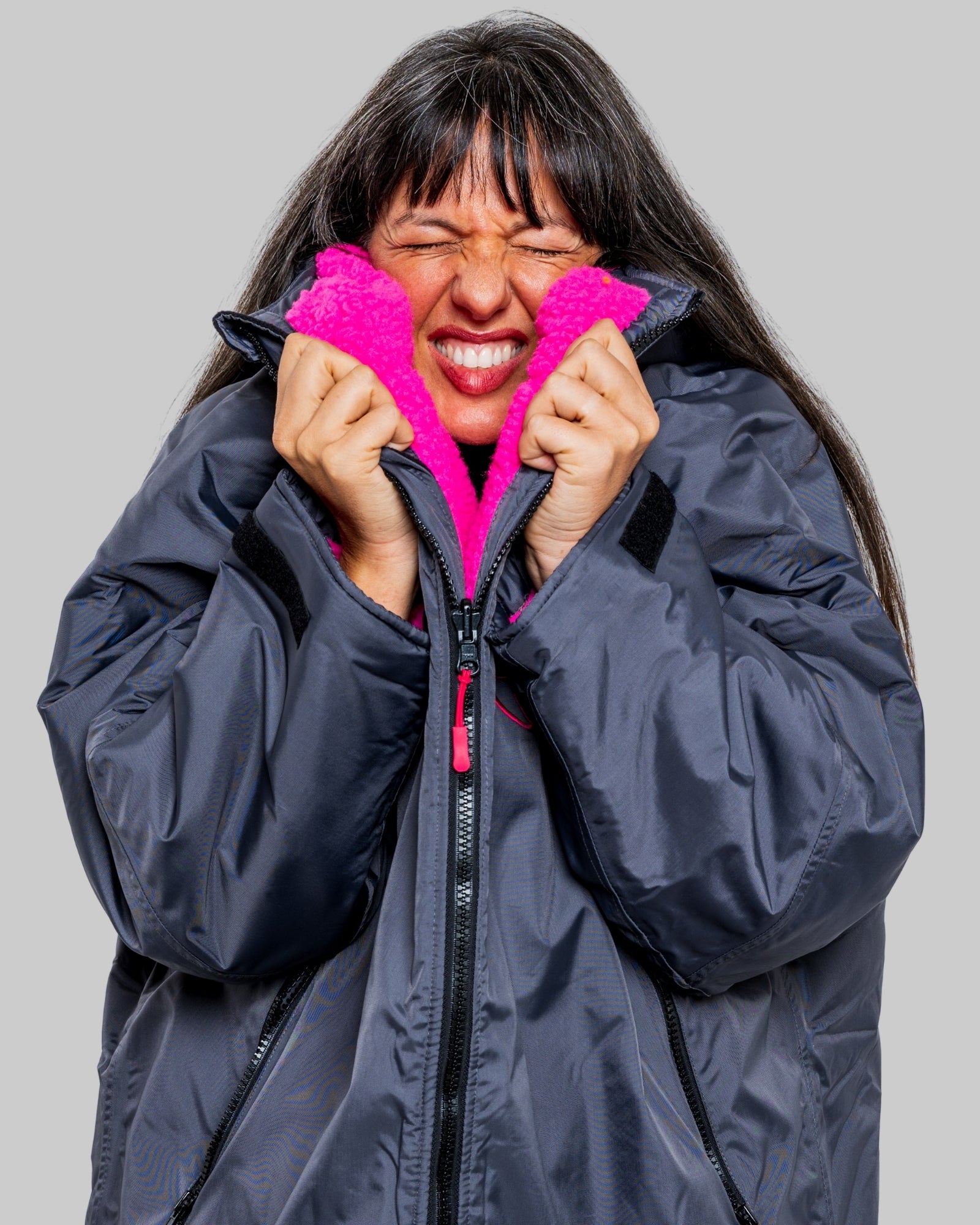 Model wearing RuggaRobe slate grey change robe with pink fleece interior on grey background