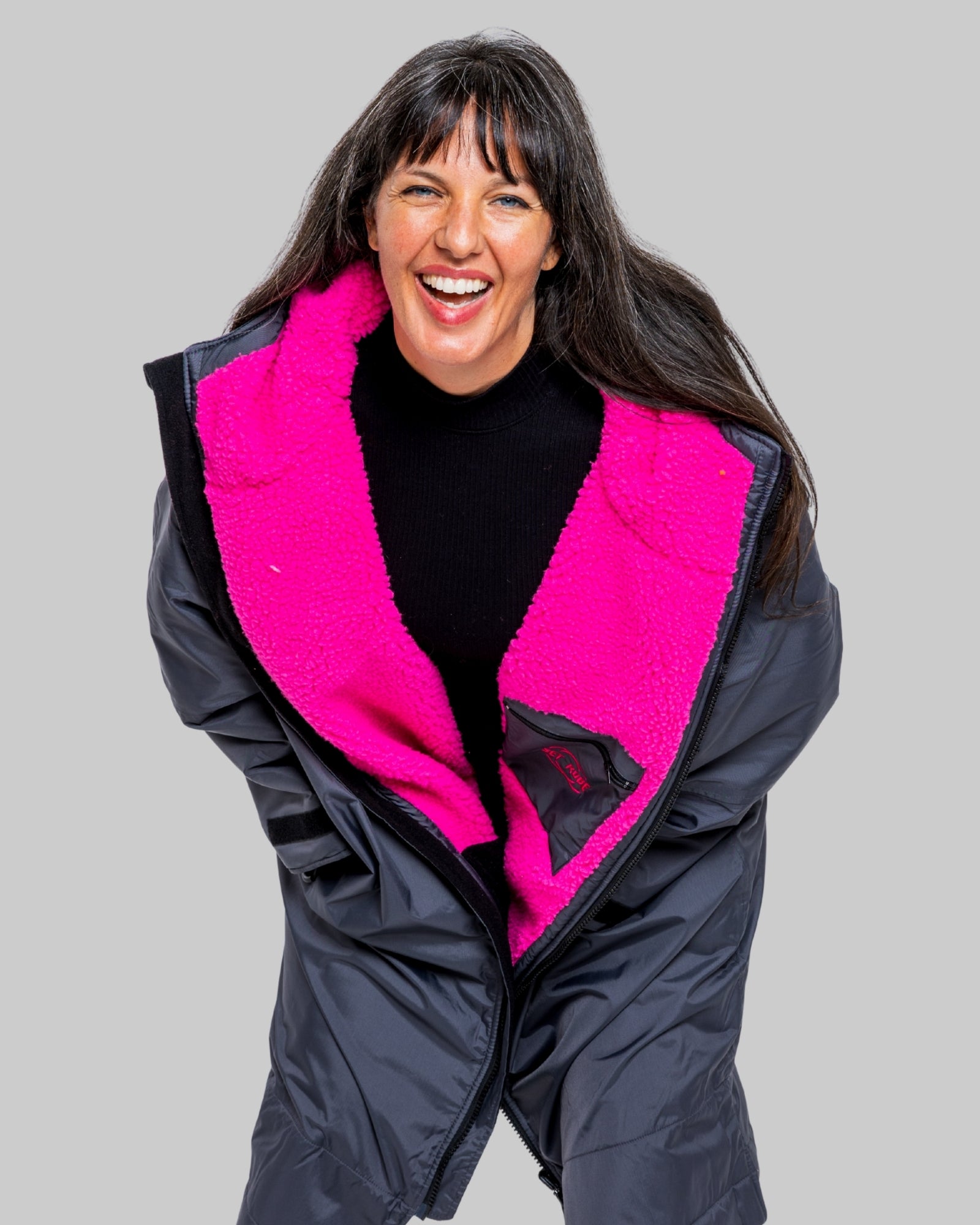 Model wearing RuggaRobe slate grey change robe with pink fleece interior on grey background