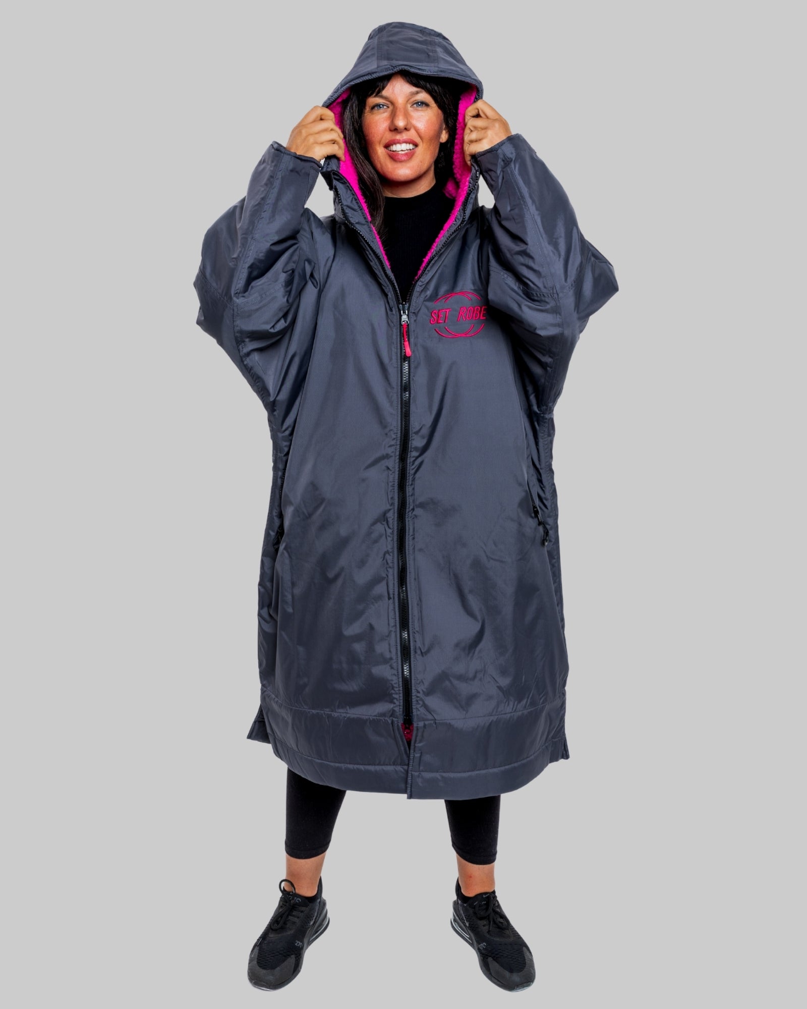 Model wearing RuggaRobe slate grey change robe with pink fleece interior on grey background