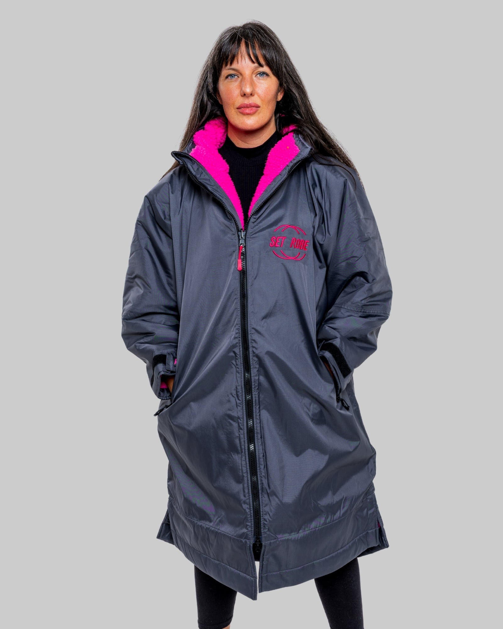 Model wearing RuggaRobe slate grey change robe with pink fleece interior on grey background