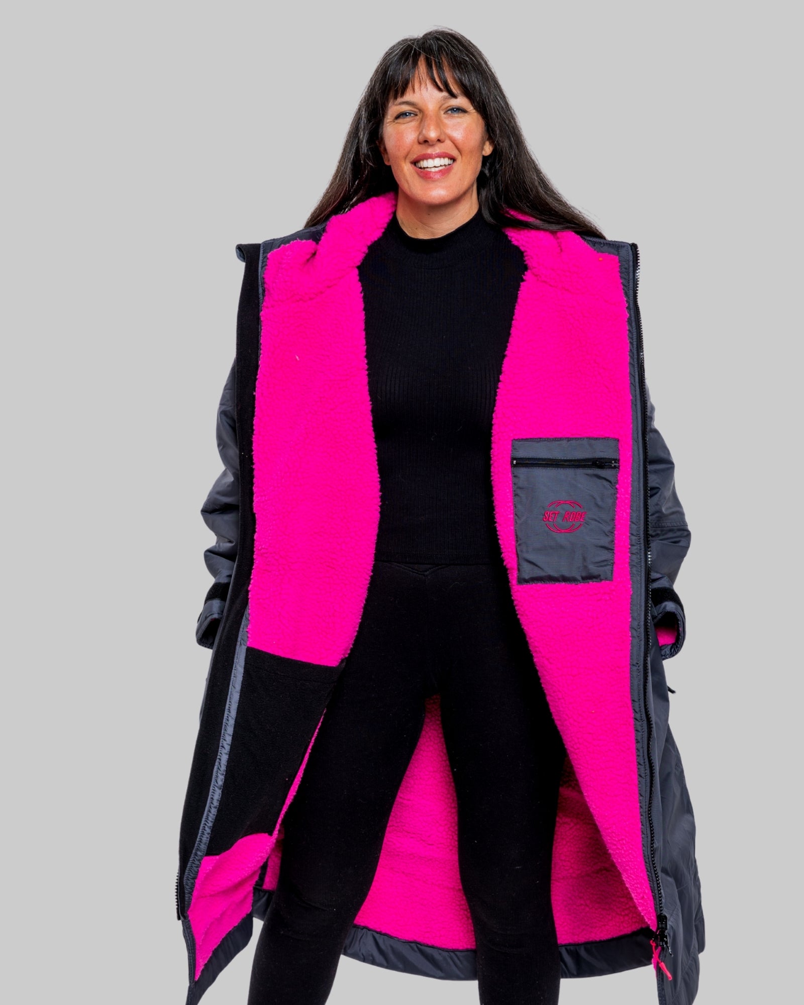 Model wearing RuggaRobe slate grey change robe with pink fleece interior on grey background