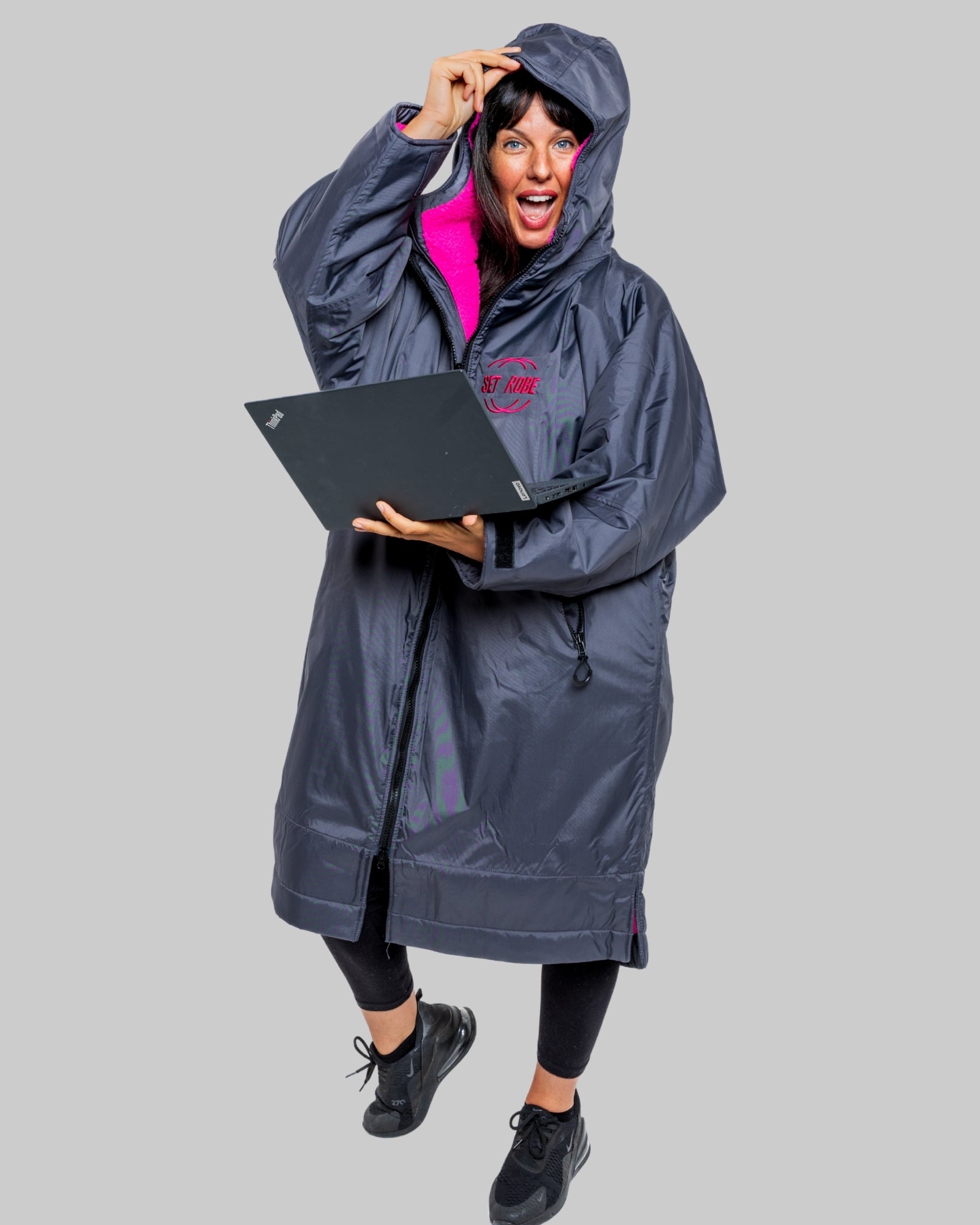 Model wearing RuggaRobe slate grey change robe with pink fleece interior on grey background