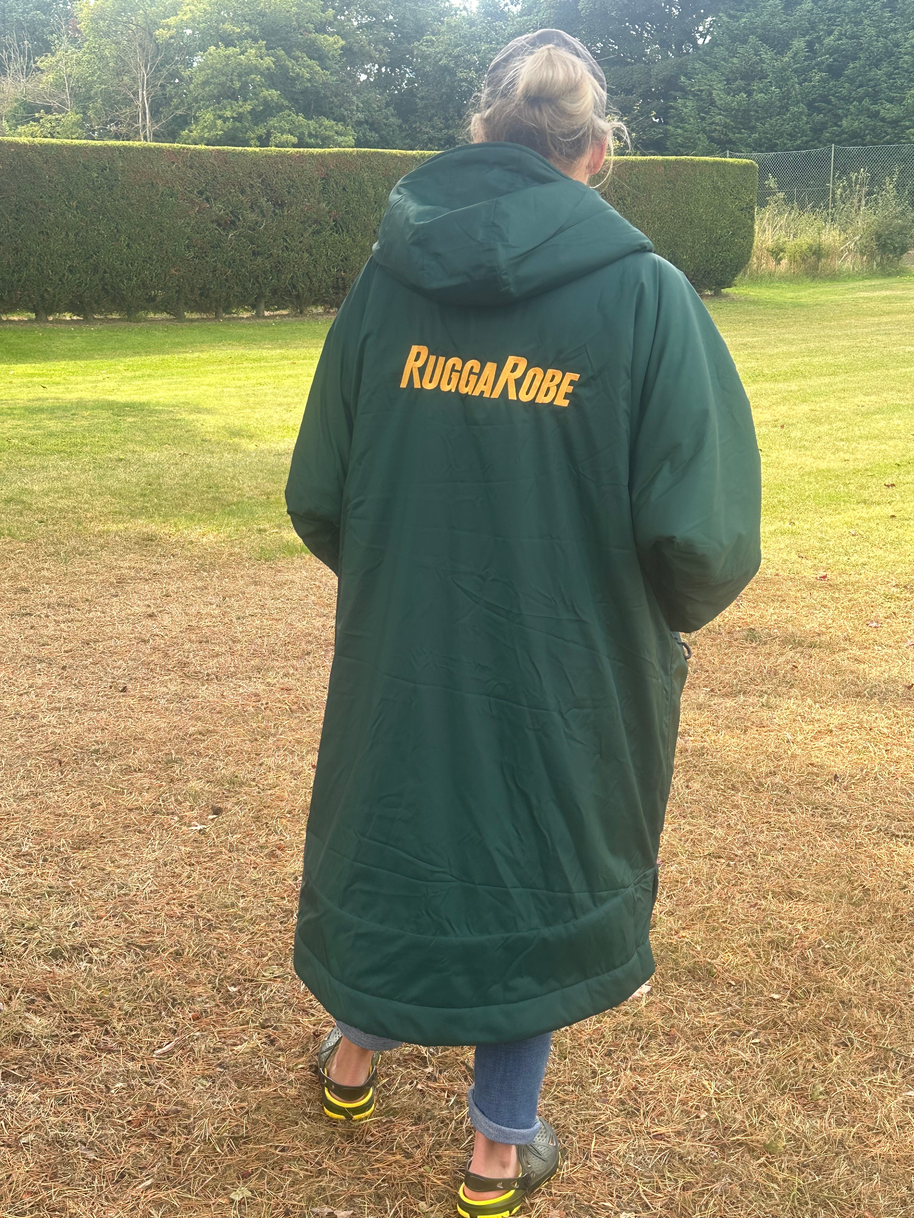 Person wearing a green with gold fleece change robe eith ruggarobe branding in a field 