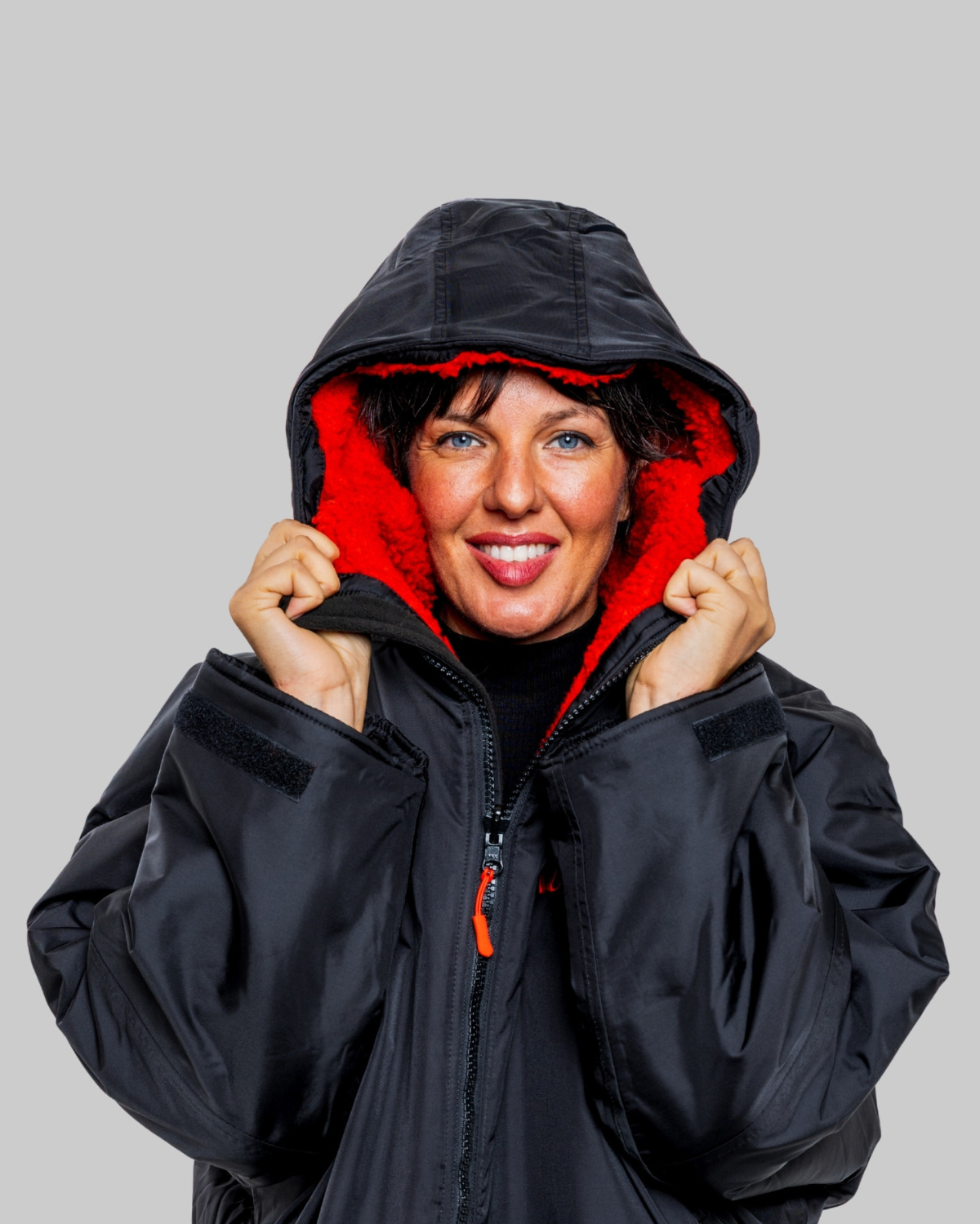 Model wearing RuggaRobe black change robe with red fleece interior and hood
